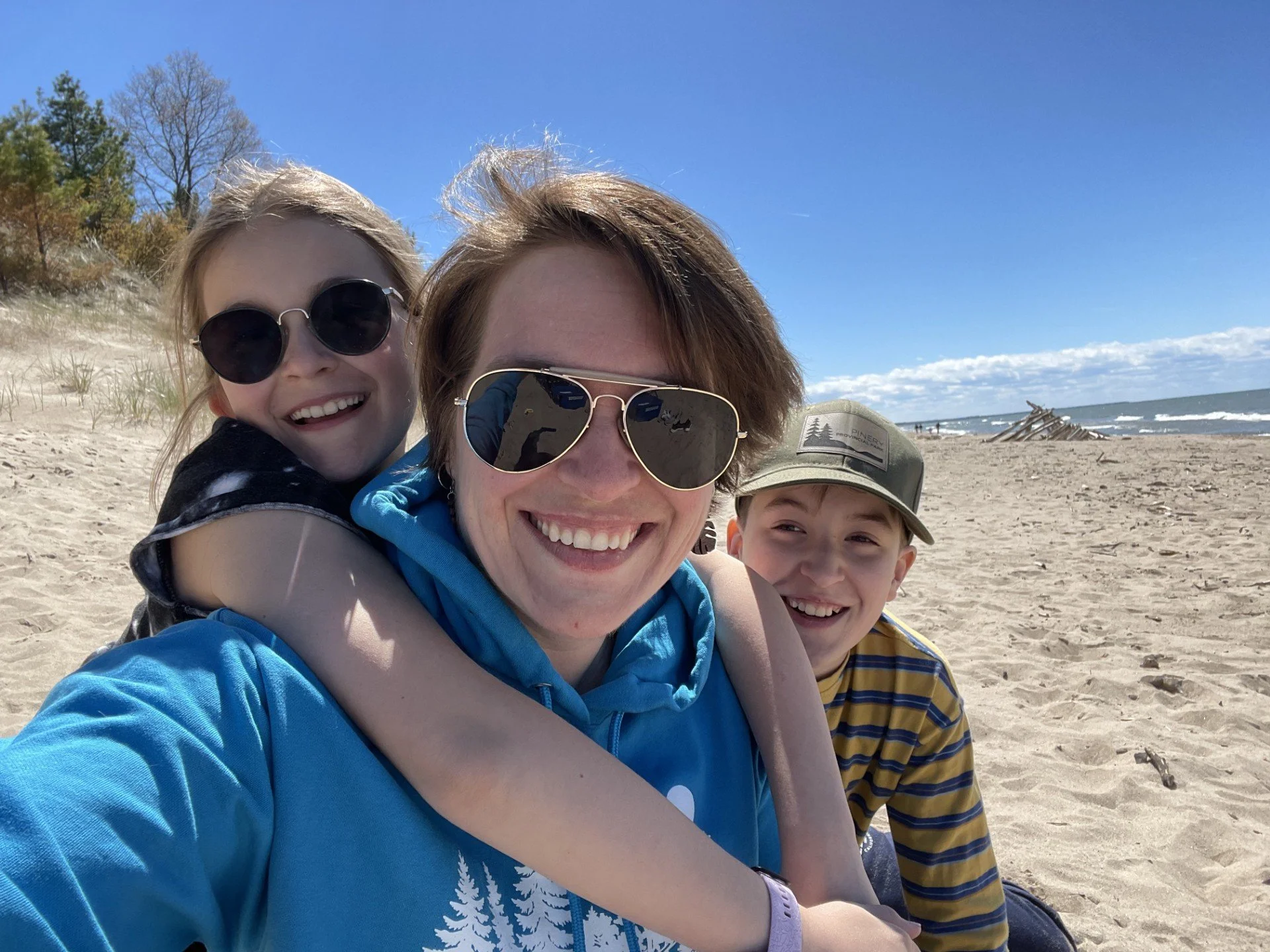 Business coach and educator smiling with her two children on a beach, reflecting the family-centred values behind her approach to sustainable entrepreneurship.