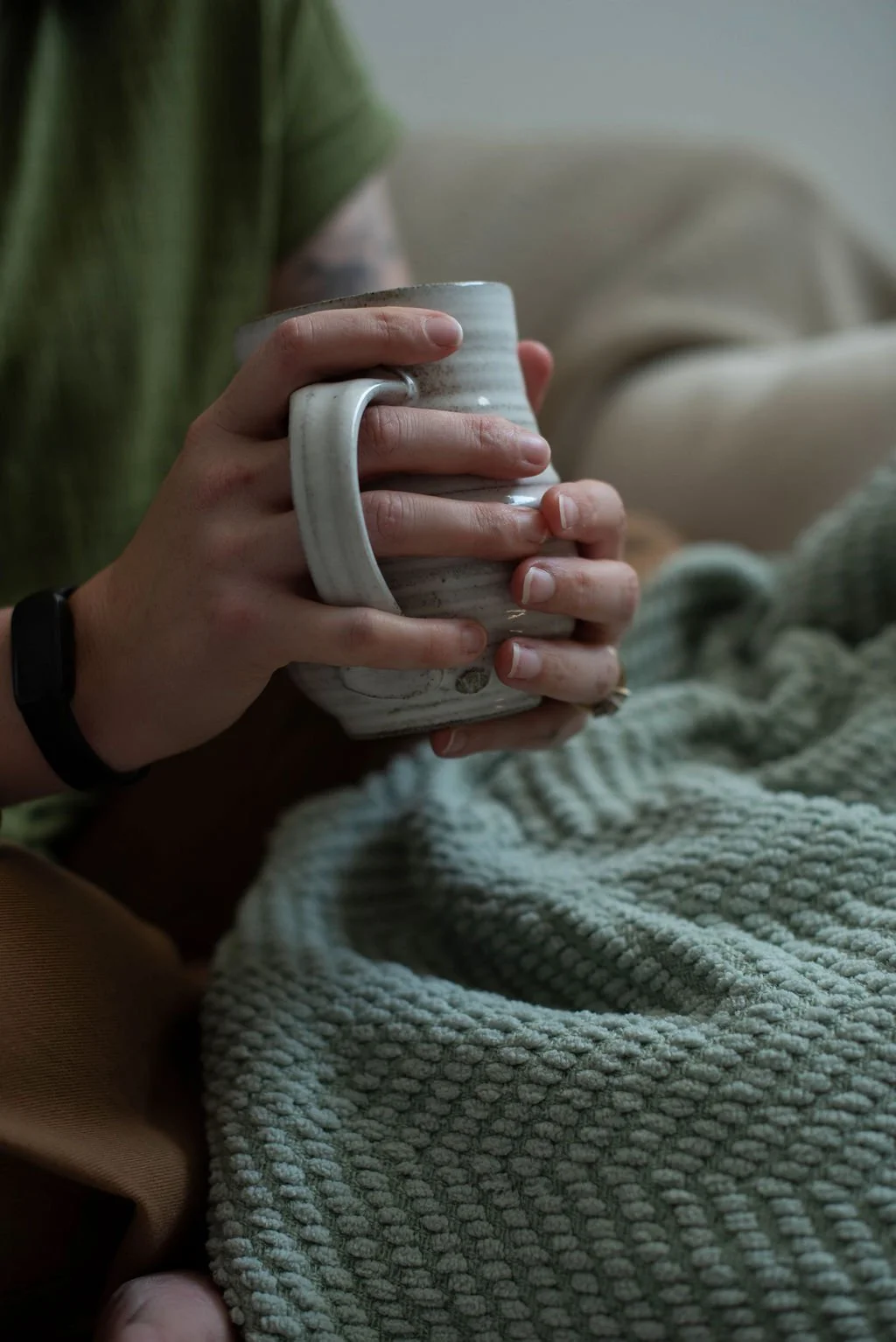 Hands holding a warm mug during a business coaching conversation about sustainable entrepreneurship, thoughtful decision-making, and building a business that fits real life.