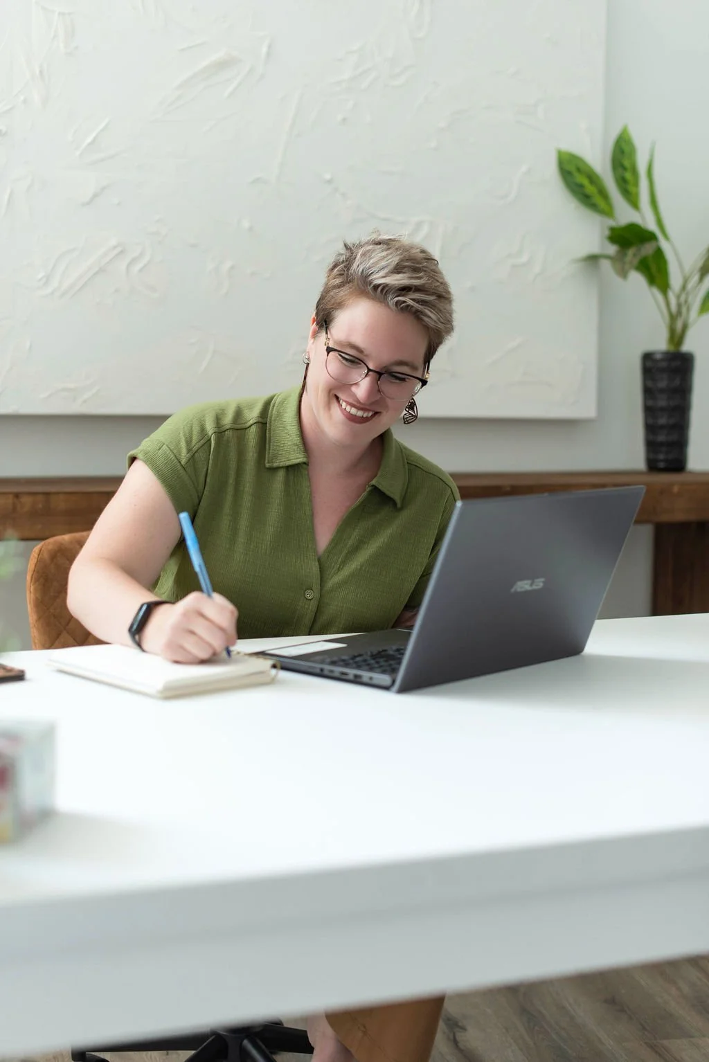 Business coach Chelsey Hart taking notes during a virtual coaching session, combining practical business education with personalized support for entrepreneurs and small business owners.
