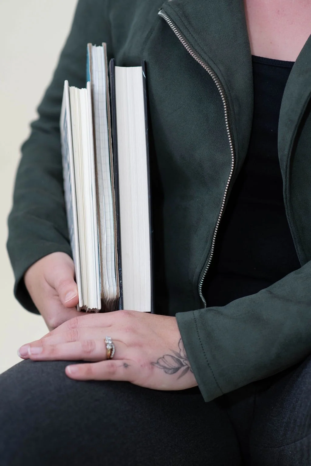 Person carrying business planning workbooks and notebooks, representing practical business education, planning, and real-world entrepreneurship.