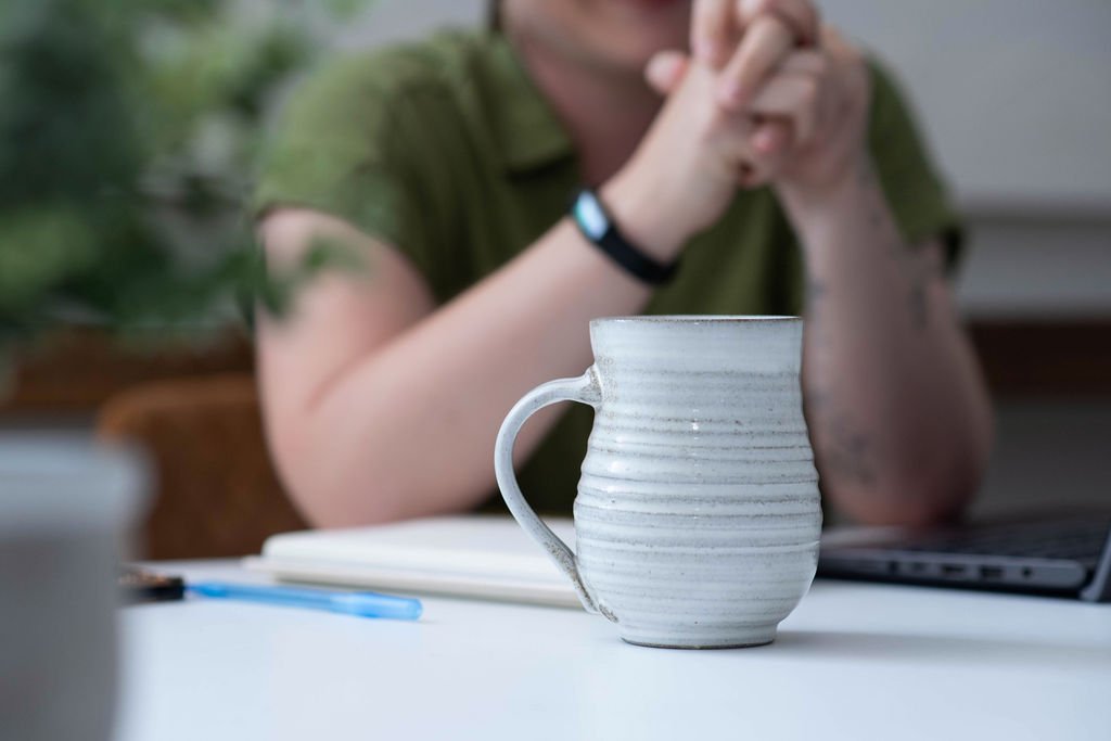 Ceramic mug on a desk during a business coaching session, representing sustainable business growth, meaningful conversations, and relationship-based entrepreneurship.