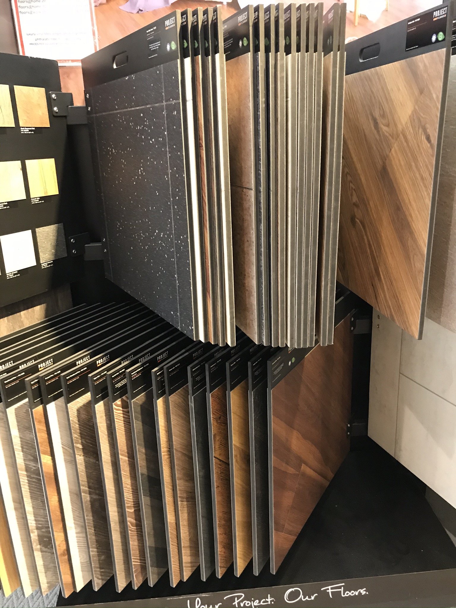Display of laminate flooring samples in various wood and stone patterns.