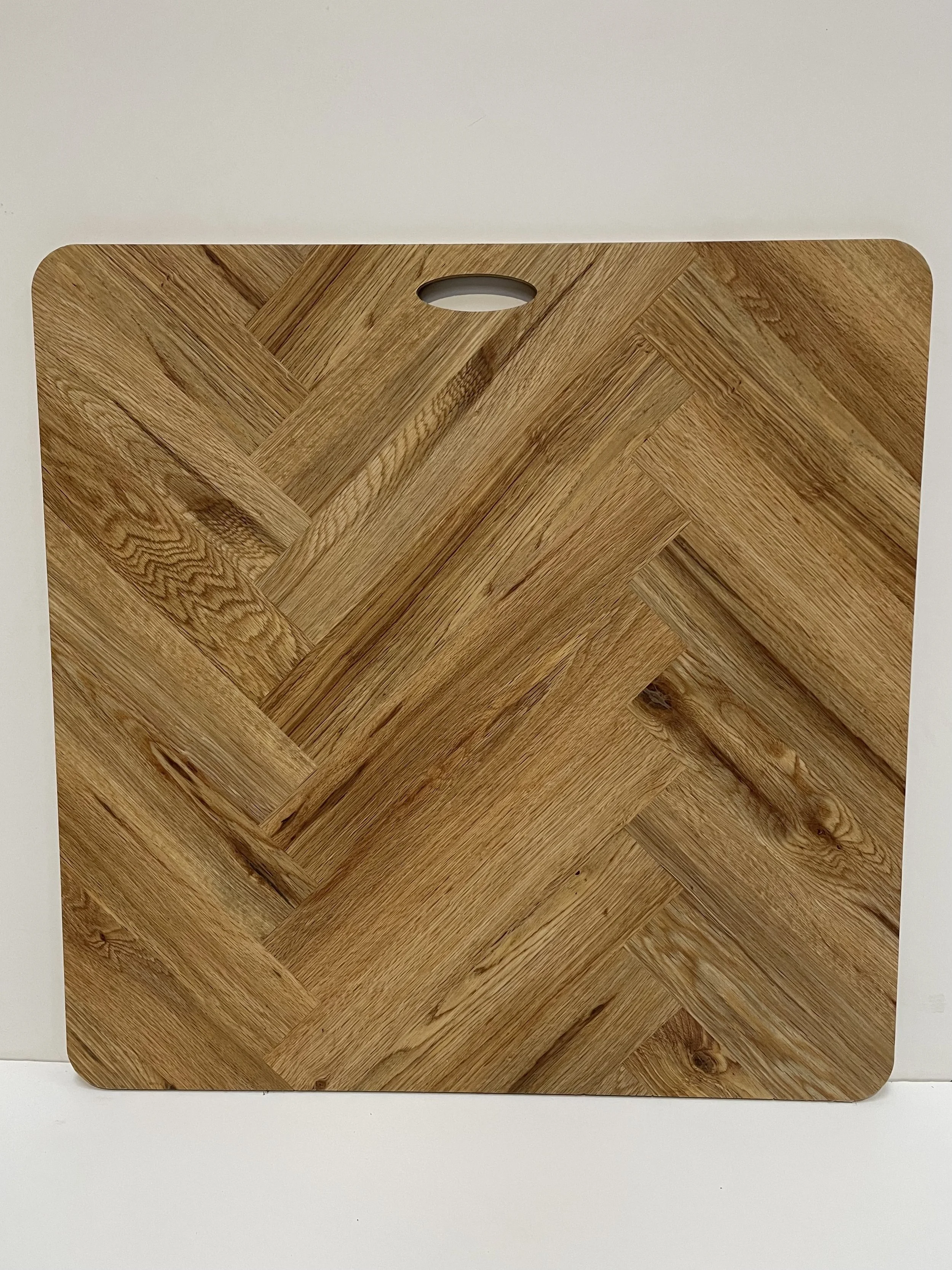 Wood grain cutting board with herringbone pattern and handle slot