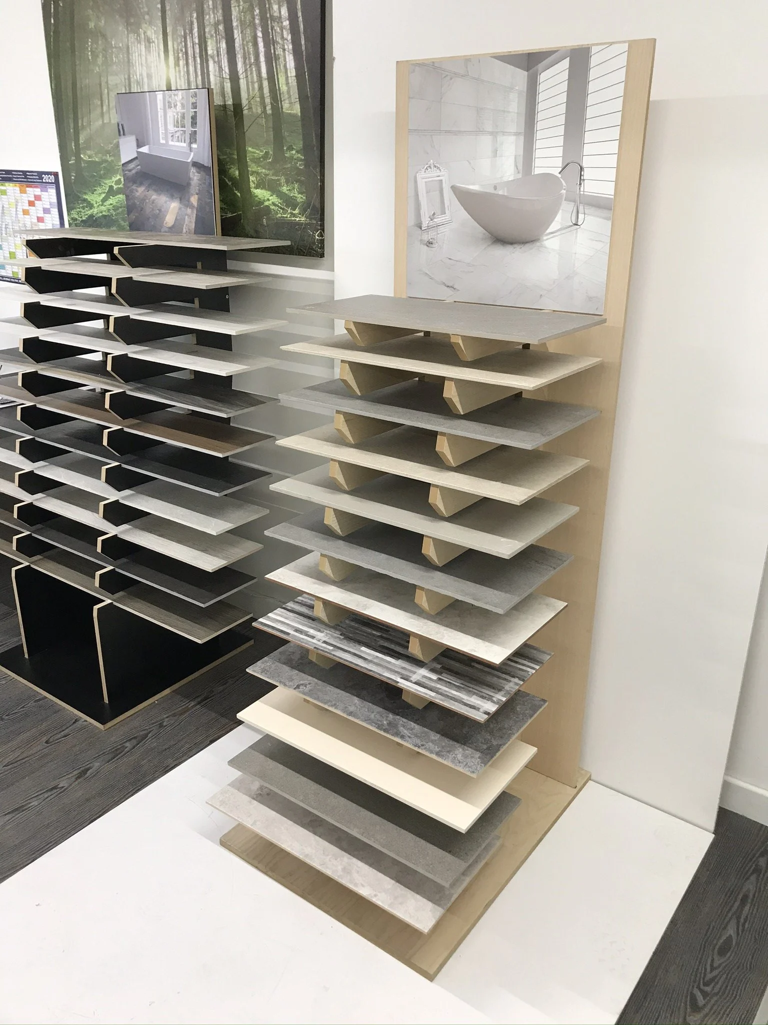 Display rack with various tile samples and a bathroom design poster in a showroom.