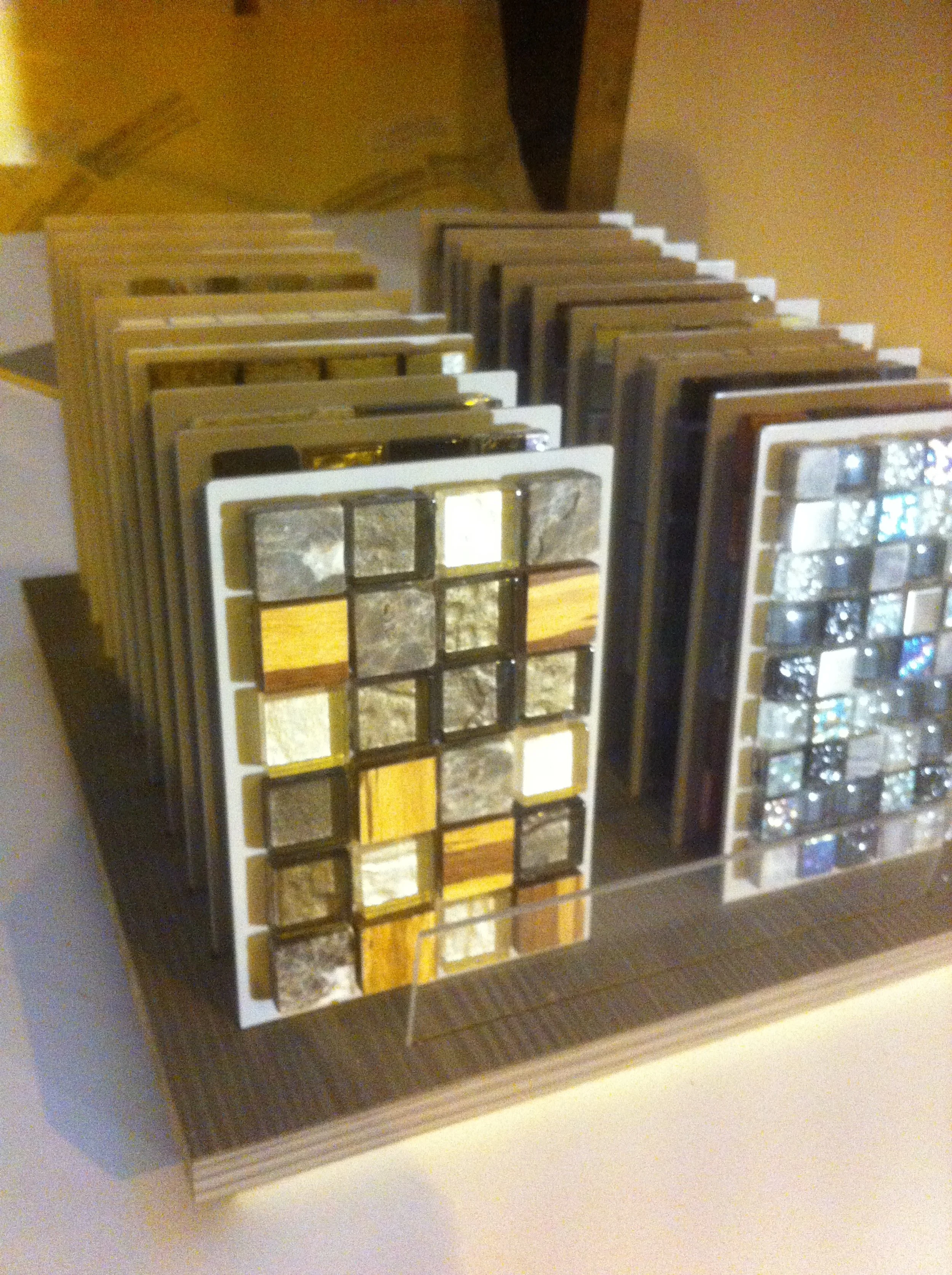 display of mosaic tile samples in various colors and materials on a stand