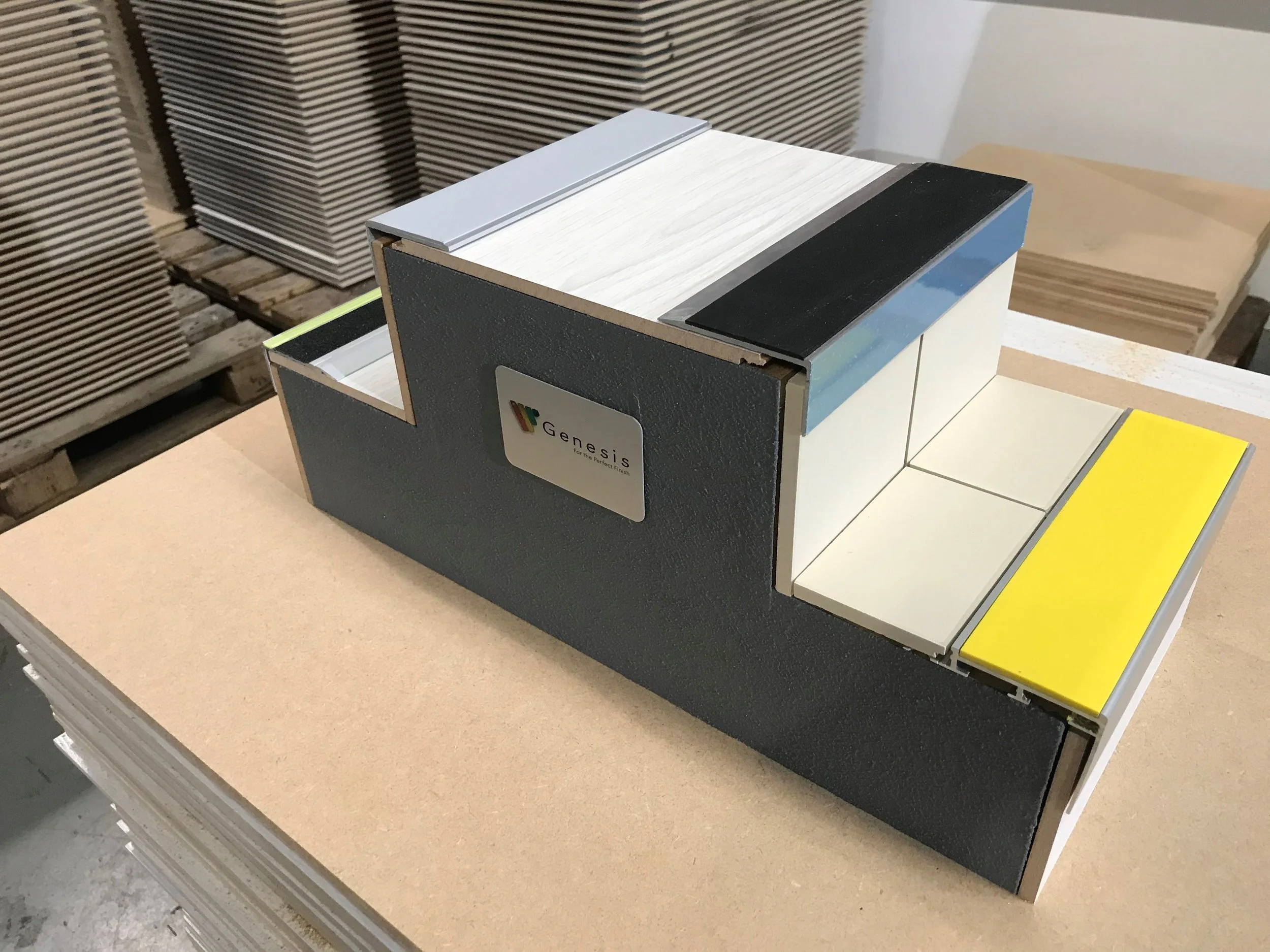 Sample of tile stair edging displaying different finishes on a stepped model in a warehouse.