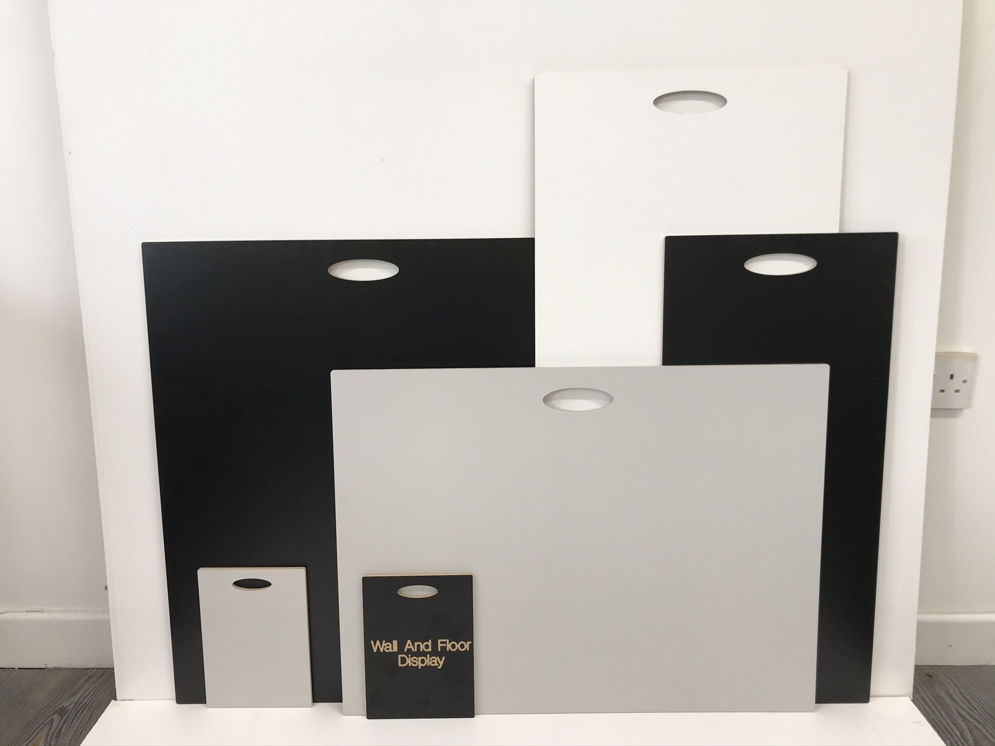 Black and white wall panels with oval cutouts arranged in a display, one labeled 'Wall And Floor Display.'