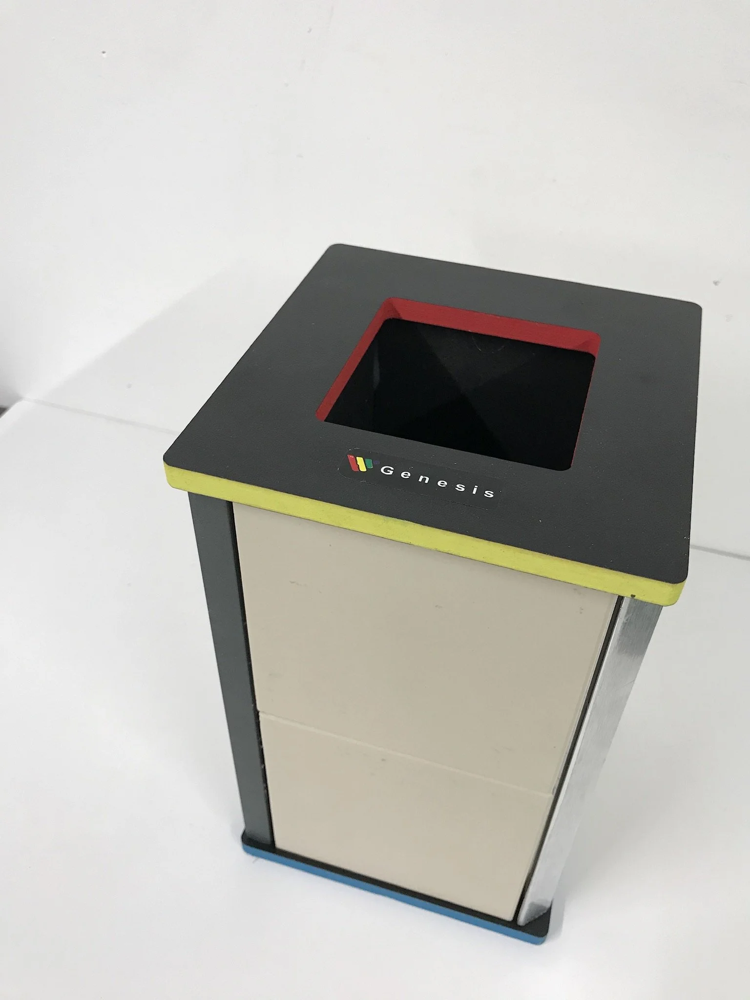 Square trash bin with Genesis logo on the lid against a white background