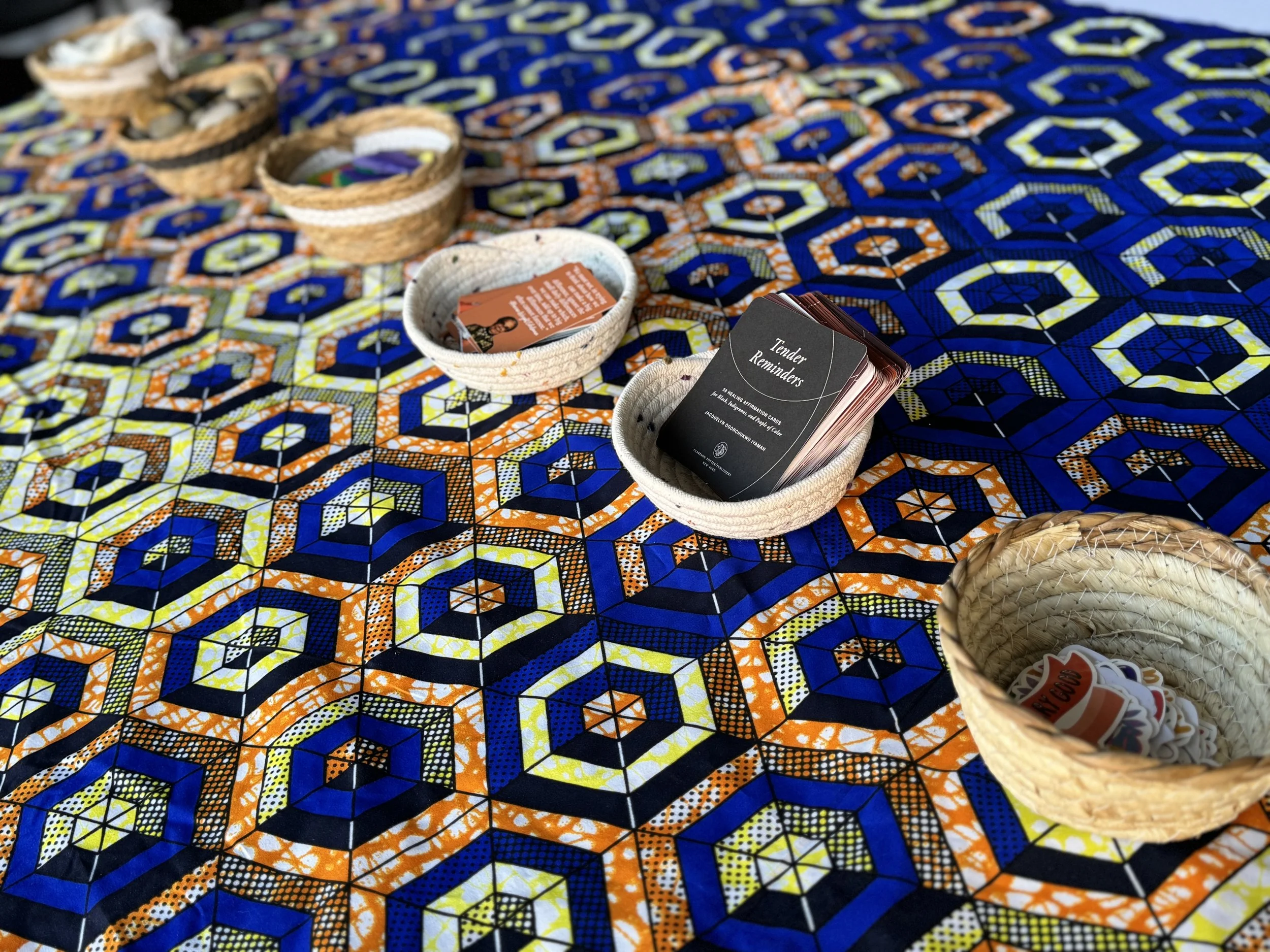 Colorful geometric patterned fabric with baskets containing business cards and small items placed on top.