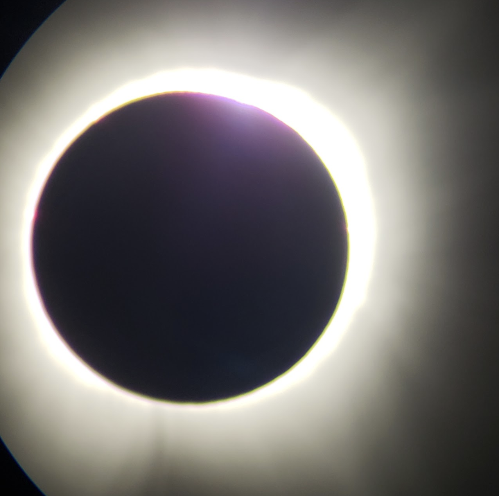 A solar eclipse showing the moon covering the sun, with a bright ring of sunlight around it.