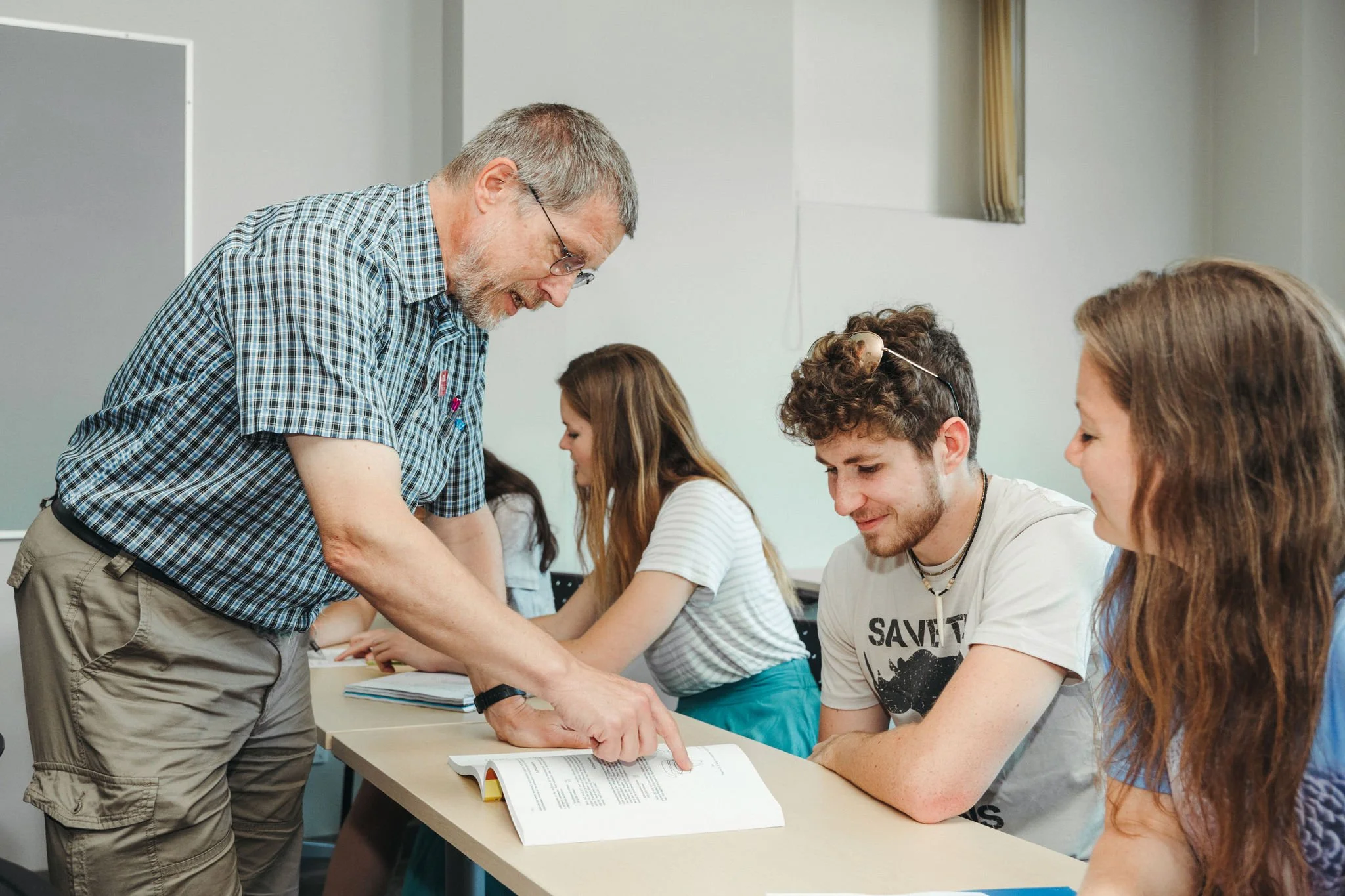A CanIL professor working with three students in the classroom.