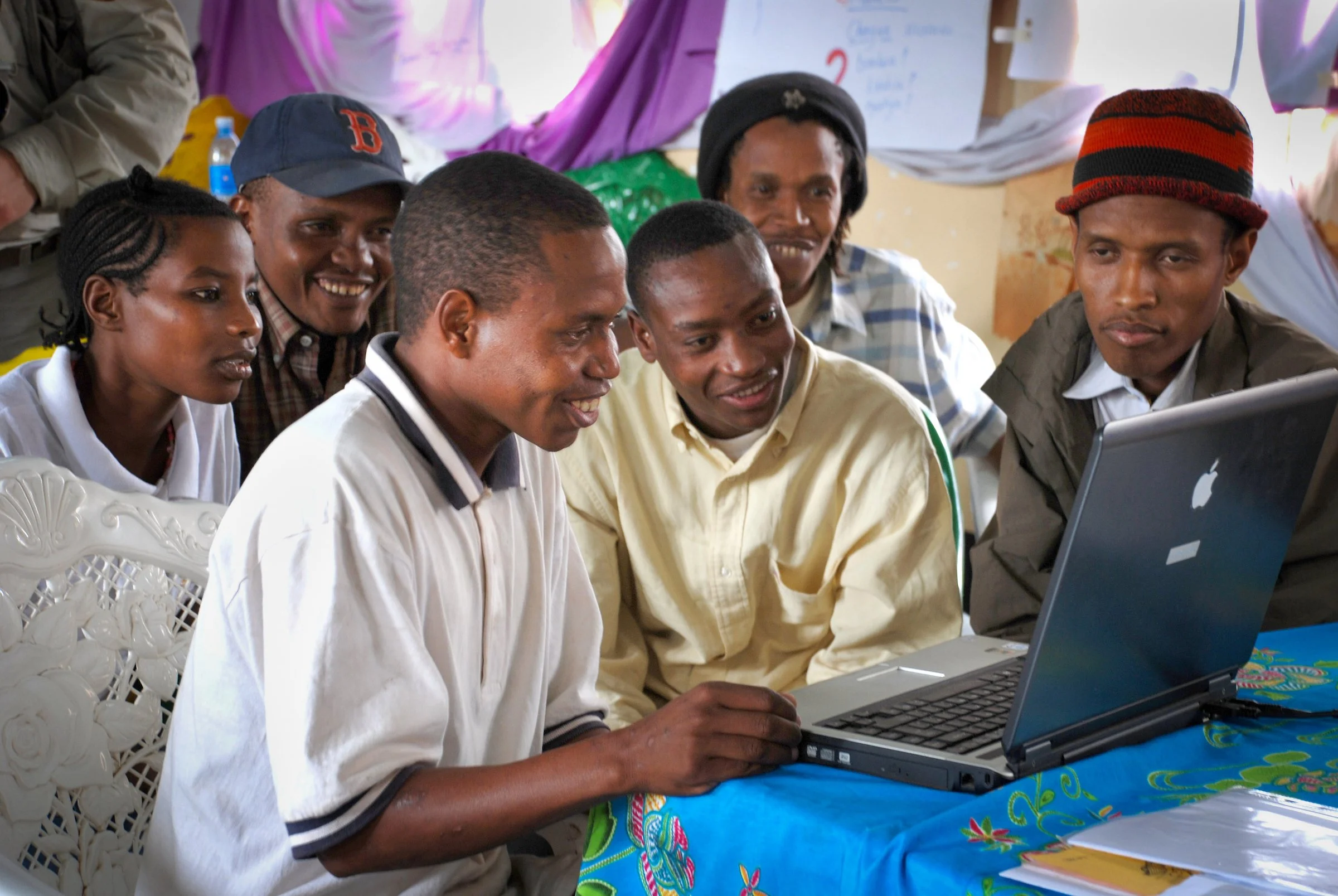 A group of people look at a computer at the Kondoa writers workshop in June 2008