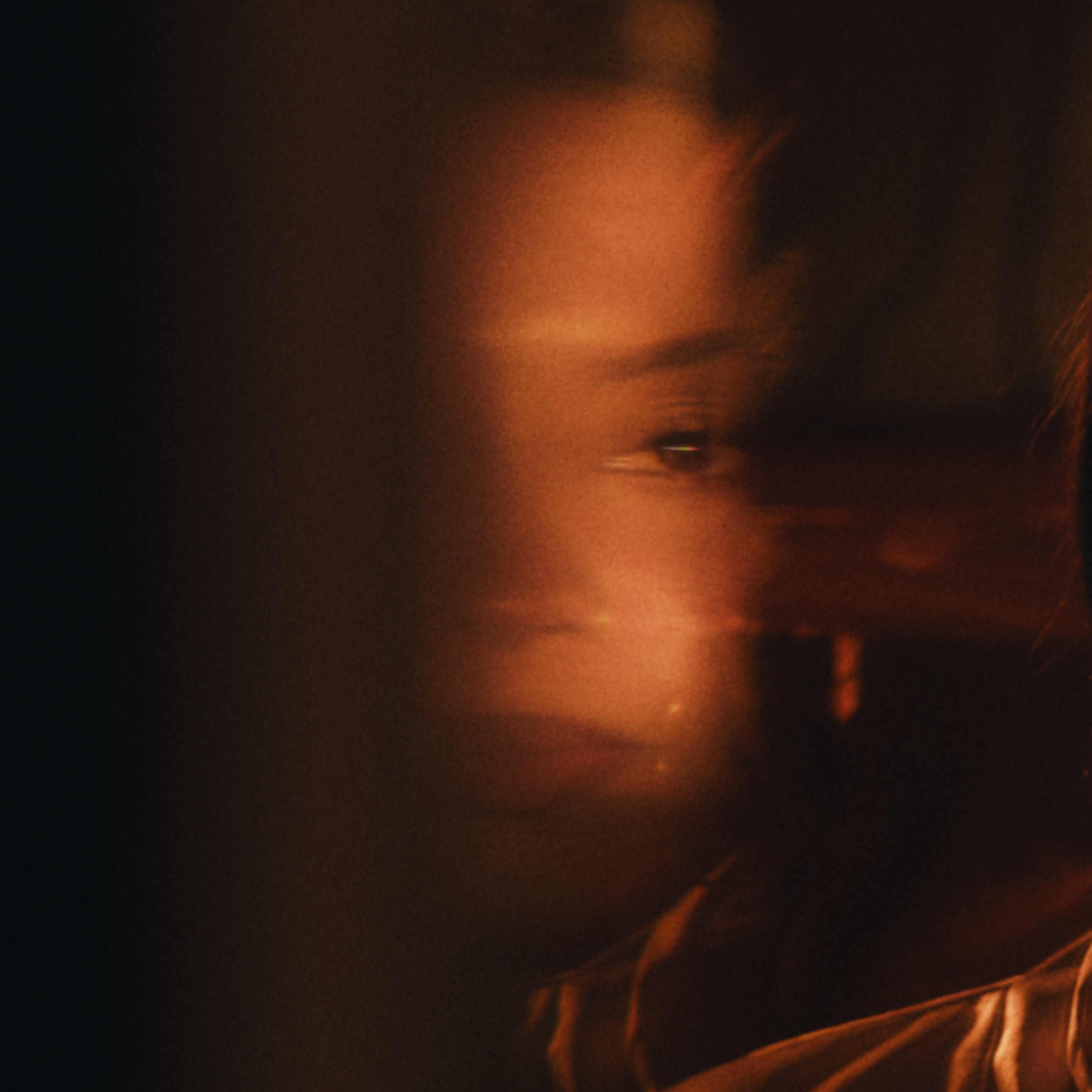 A blurry image with dark background and orange light streaks.