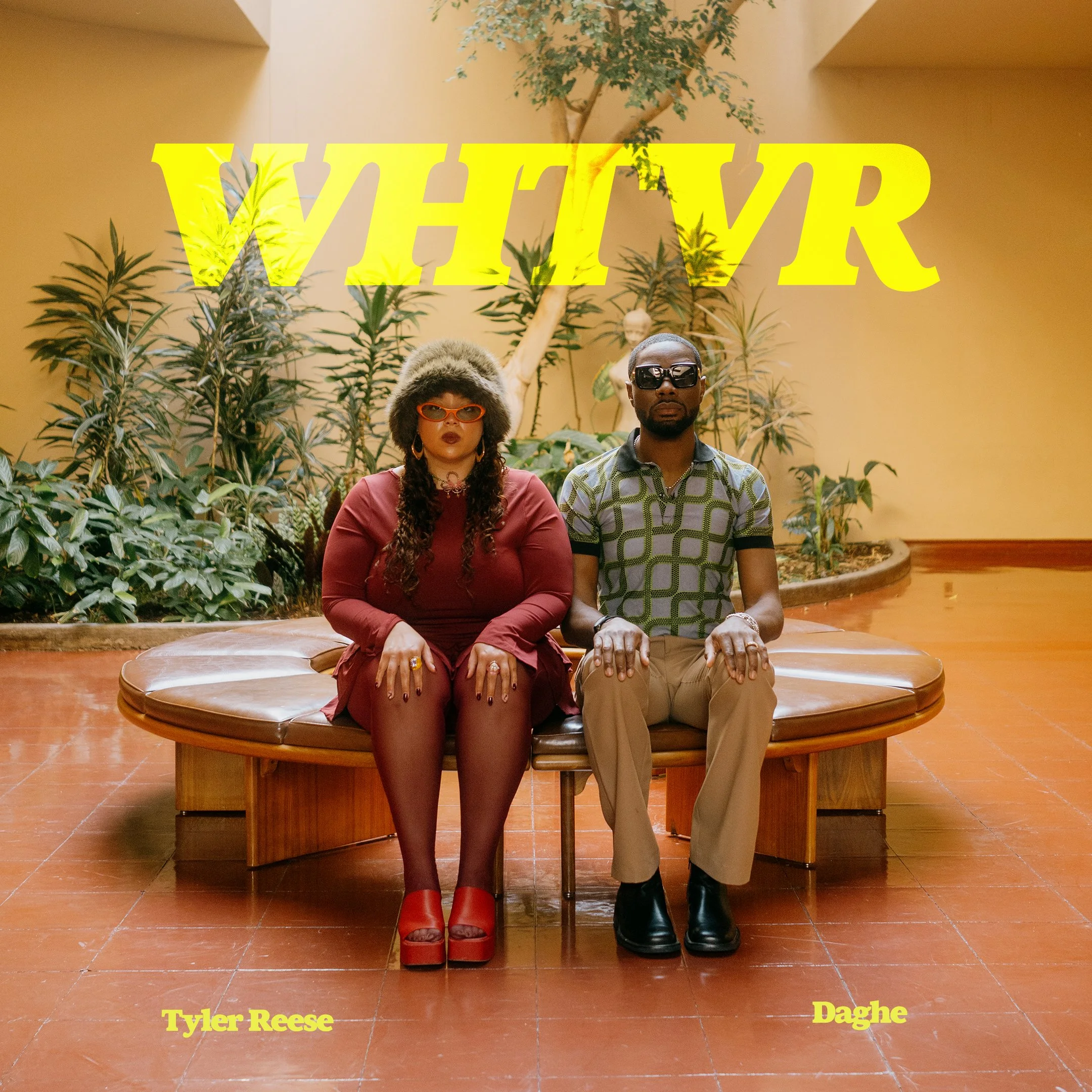 Two people sitting on a circular bench in an indoor setting filled with lush green plants. The woman on the left is wearing a fluffy hat, red shoes, and glasses, while the man on the right is wearing sunglasses and a patterned shirt. The word 'WIN' is overlaid in large yellow text, and the names 'Tyler Reese' and 'Daghe' are written in yellow at the bottom corners of the image.