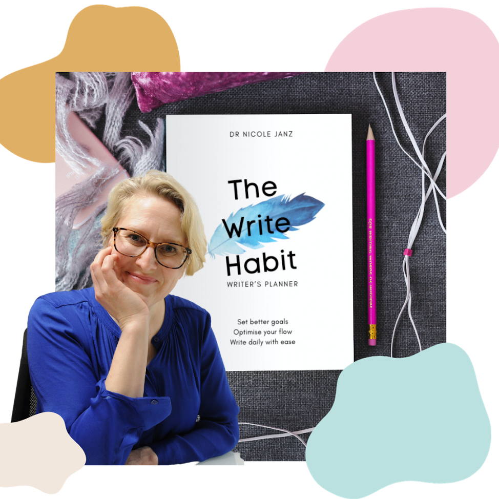 A woman with blonde hair and glasses resting her chin on her hand, smiling, sitting in front of a desk with a book titled 'The Write Habit' by Dr. Nicole Janz, a pink pencil, and white earphones on a dark fabric surface surrounded by colorful abstract shapes.