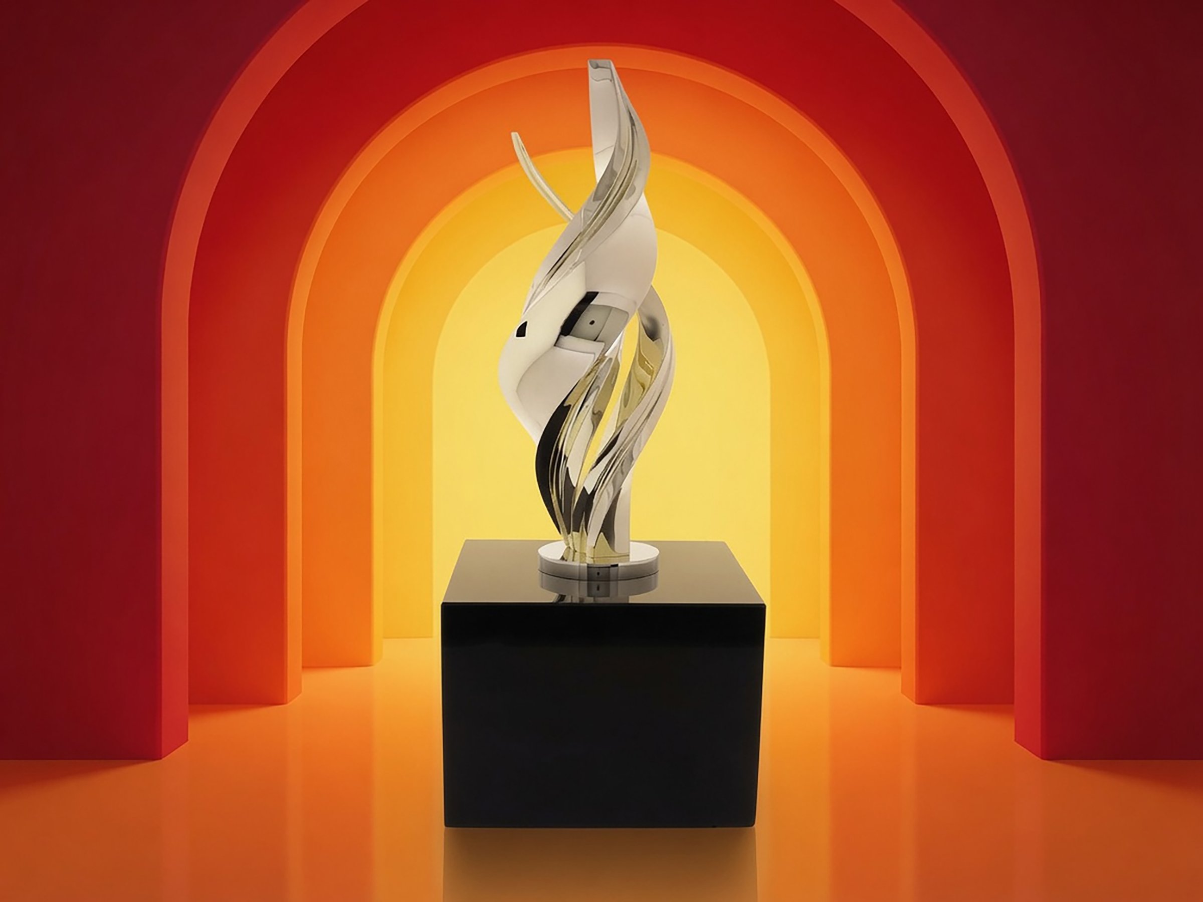 An abstract corporate award sculpture with twisting metallic ribbons displayed on a pedestal in a vibrant red and yellow gallery setting.