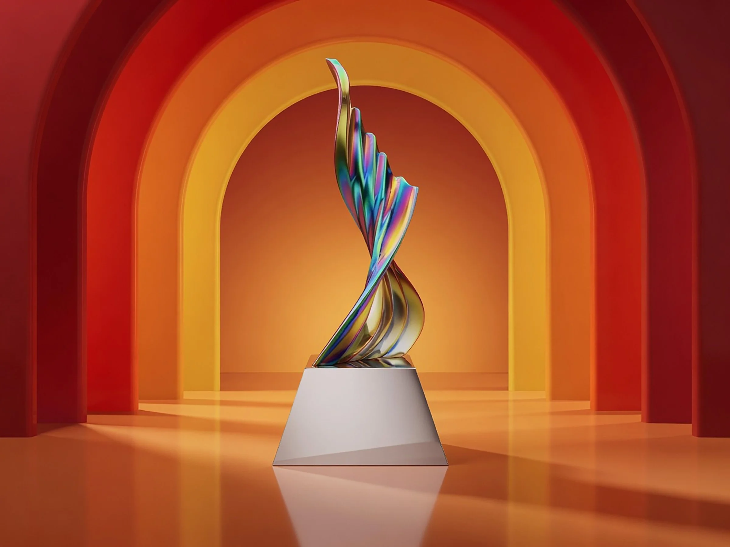 A colorful, abstract sculpture of a hand with a rainbow spectrum of colors, placed on a pyramid-shaped white pedestal against a vibrant orange and red arched background.