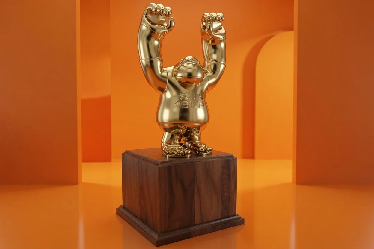 Gold-colored trophy of a cartoonish character with raised fists, standing on a wooden base against an orange background.