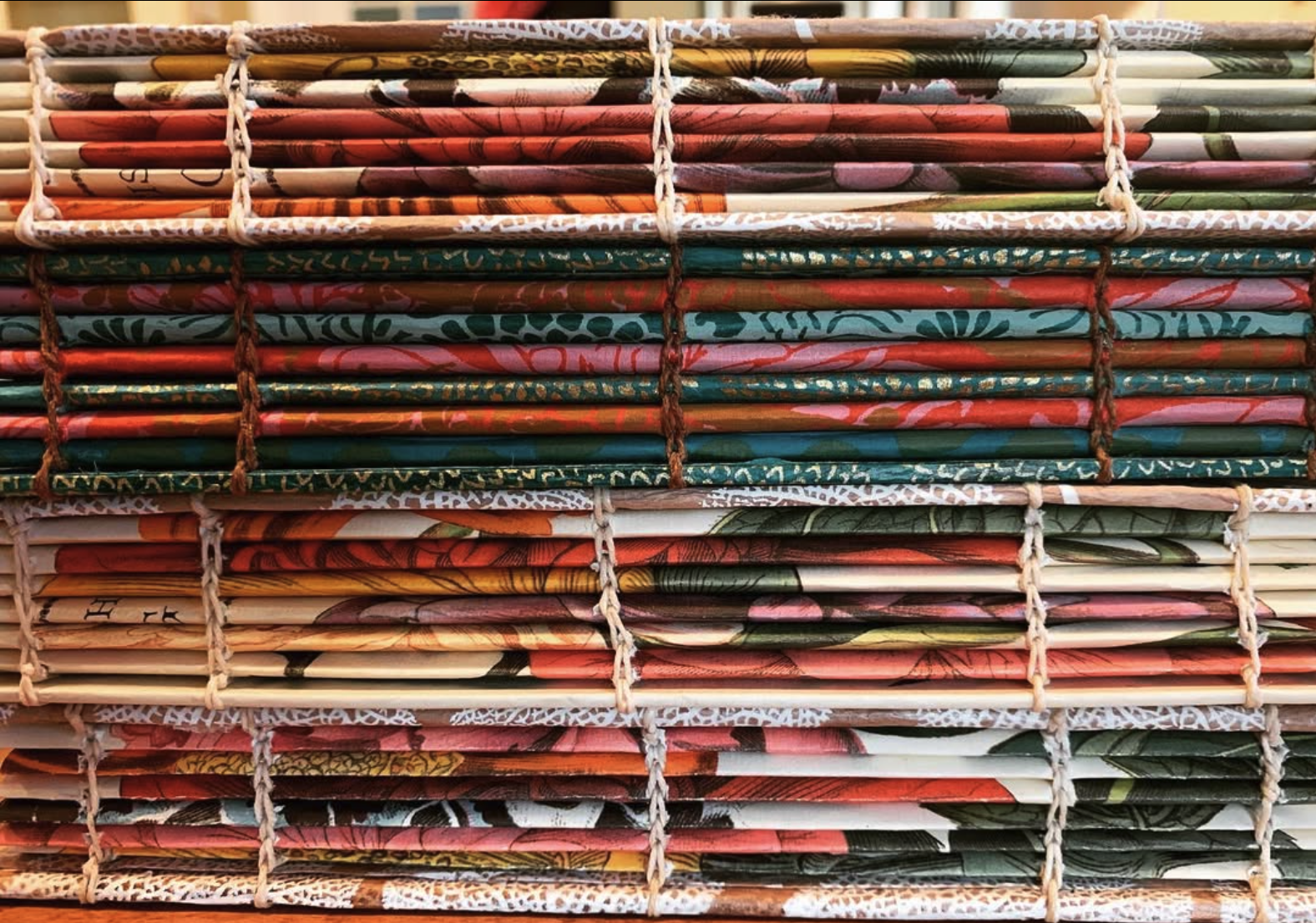 Stacked paper umbrellas, arranged in neat rows inside a bamboo or wooden rack.