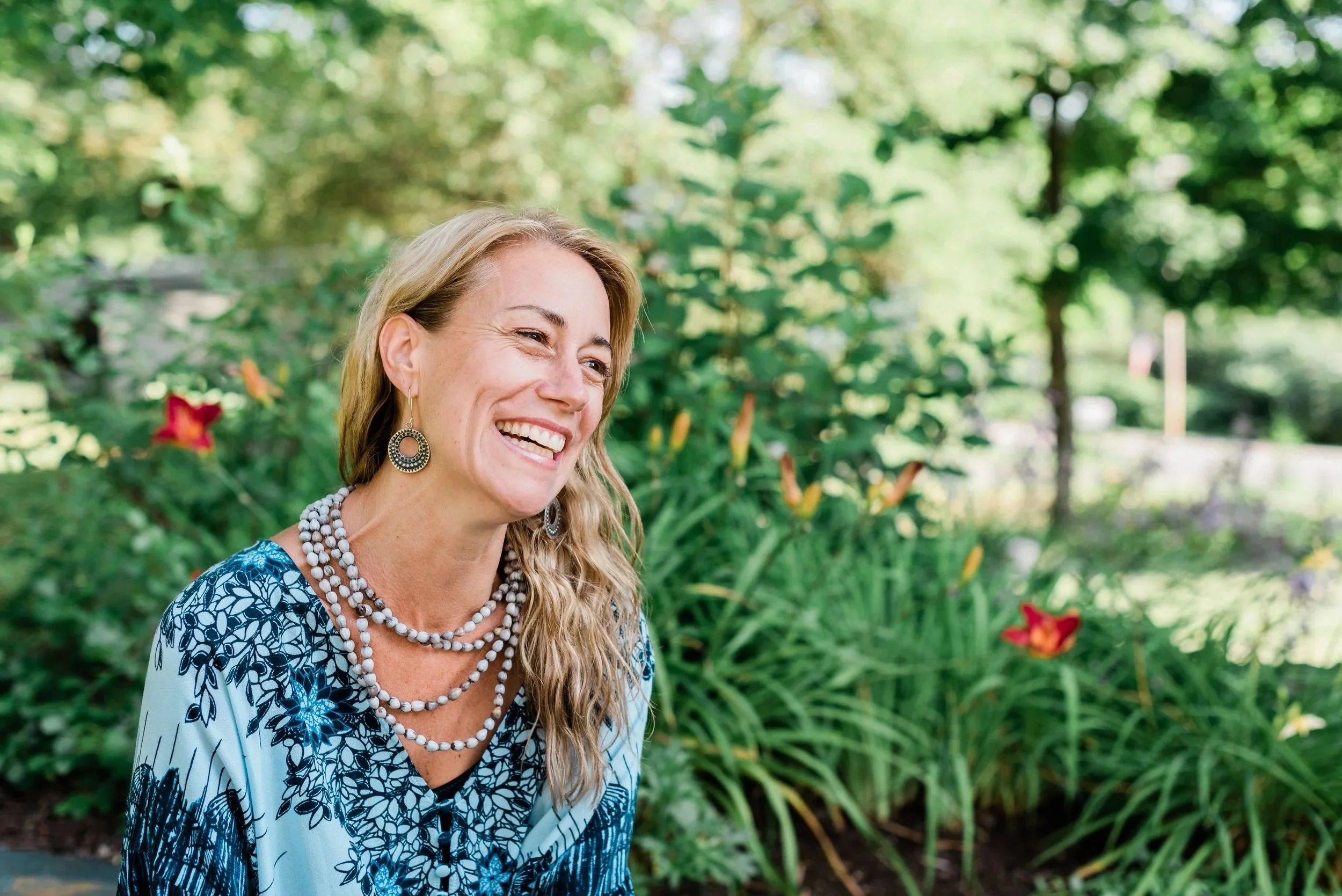 Jordane Baker, founder of Heavenscent Floral Art, Burlington VT wedding florist, smiling in her Vermont flower garden