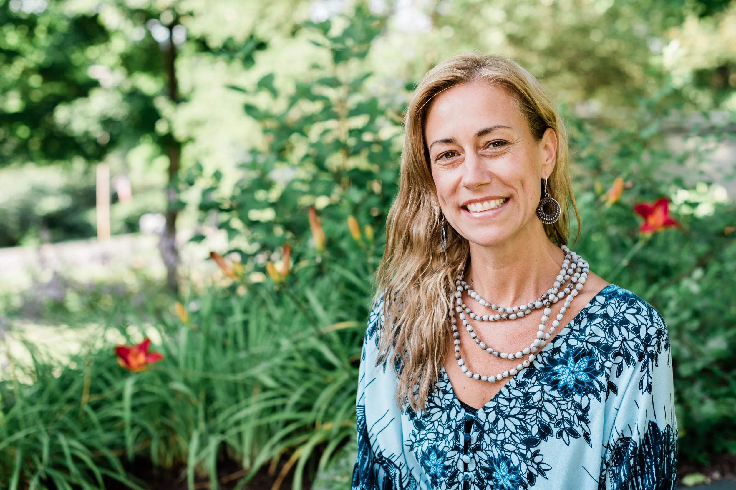Jordane Baker, founder of Heavenscent Floral Art, Burlington VT wedding florist, smiling in her Vermont flower garden