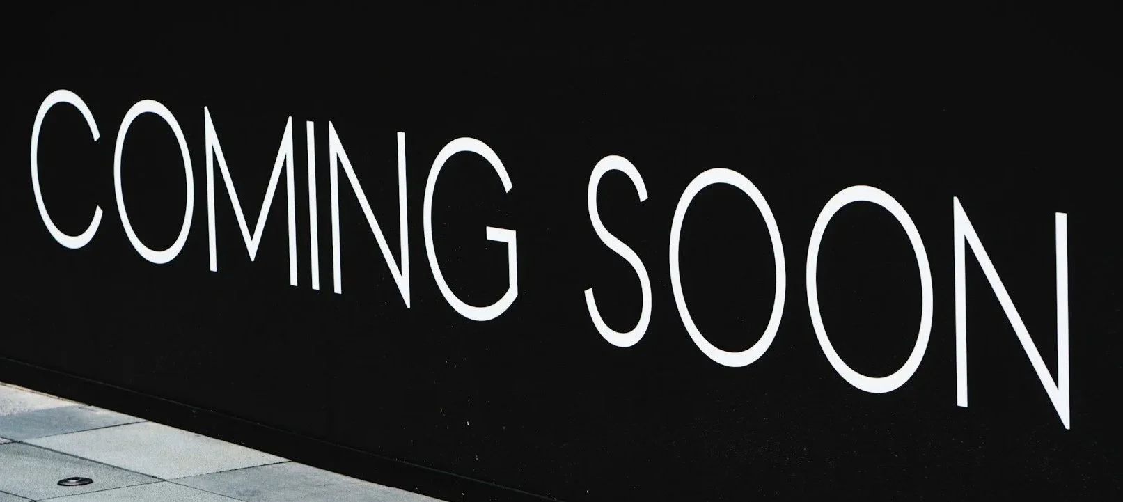 Black wall with white text that reads 'Coming Soon'.