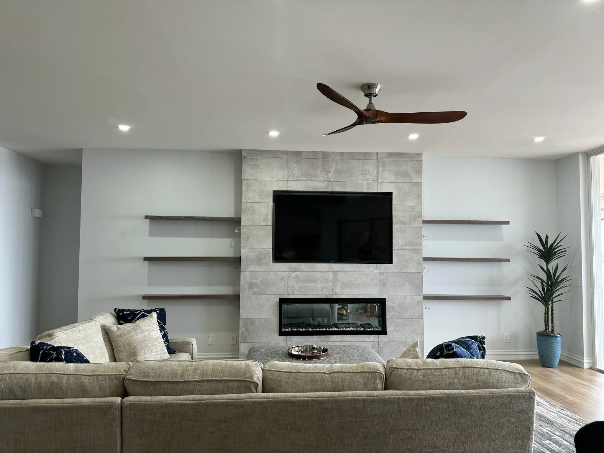 Luxury livingroom with custom fireplace, built-in shelving and modern finishes in a Sarasota custom home