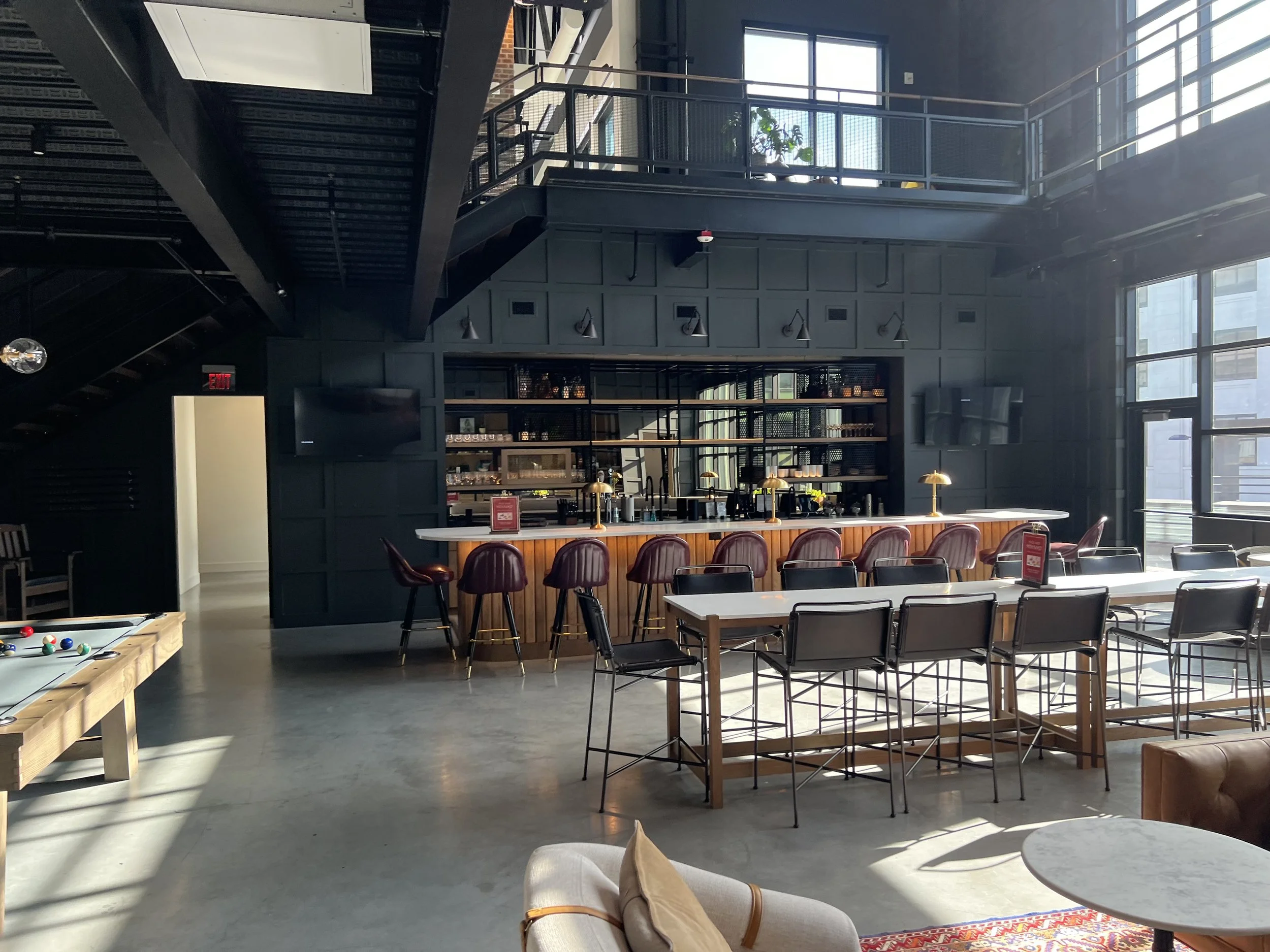 Modern commercial interior built-out with custom staircase, bar area, and contemporary finishes in Naples Florida