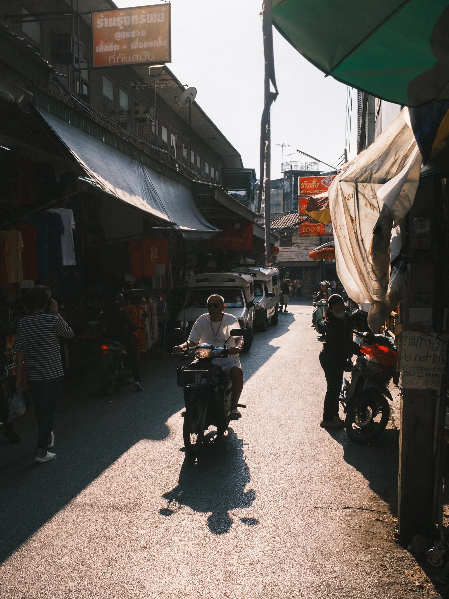 Man on a scooter driving on a street in Chinatown Chiang Mai Thailand