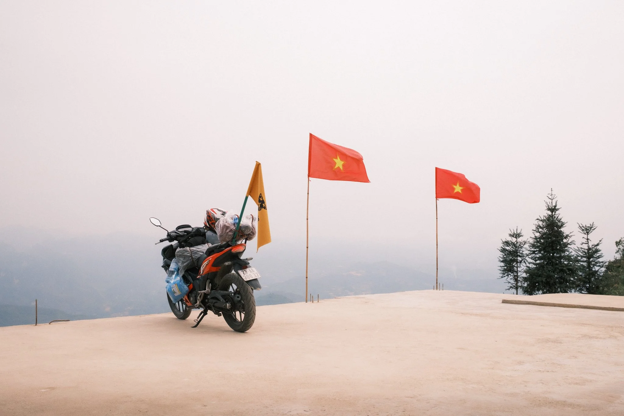 Motorcycle on the Ha Giang Loop in Vietnam surrounded by Vietnamese flag