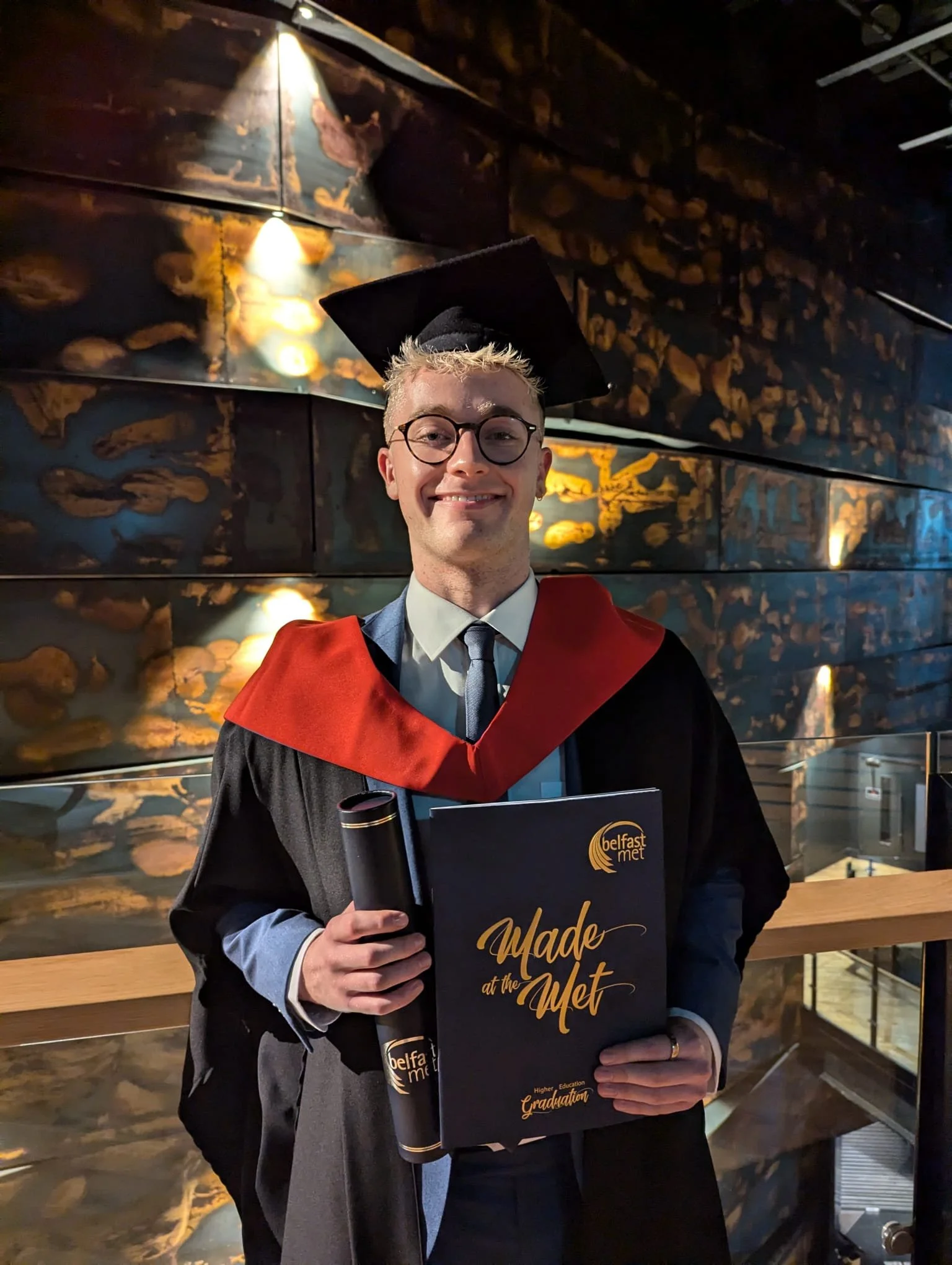 Nathan Maguire, Game Development Graduate, holding graduation certificate.