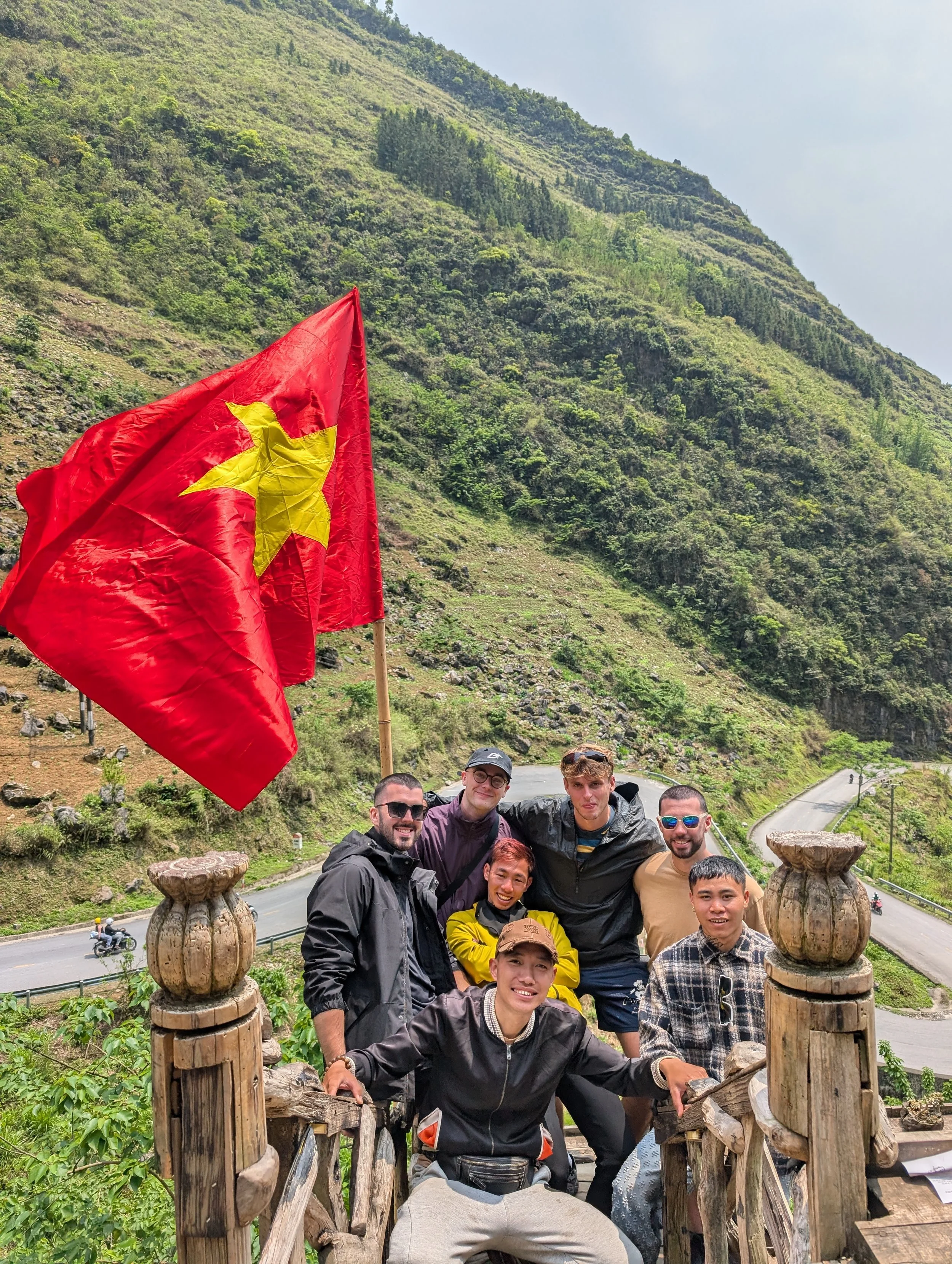 Nathan Maguire travelling with friends on a scenic mountain bridge in Ha Giang, Vietnam.