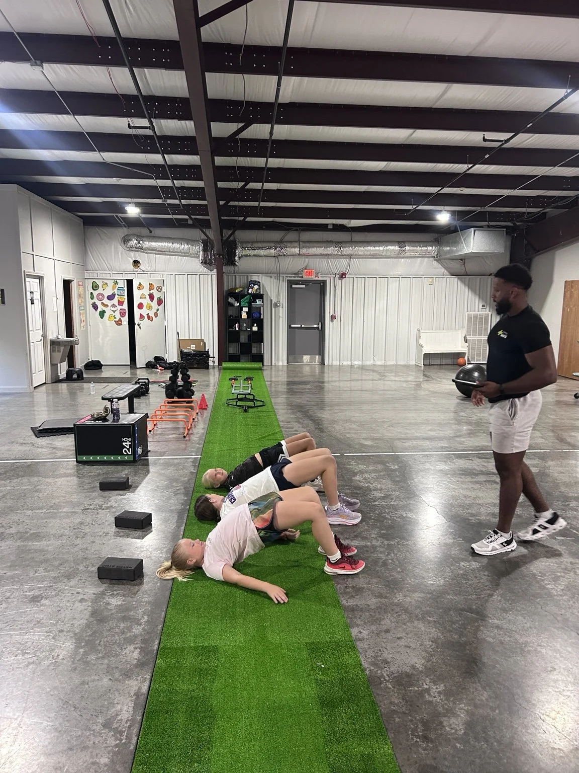 Athletes completing a coached training session on the turf at the 7th Period facility.