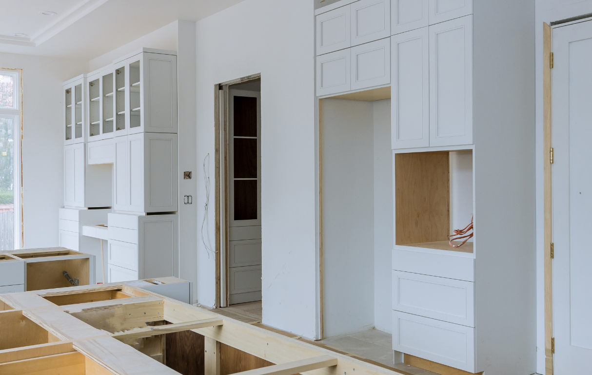 Kitchen renovation with new cabinets, open space for appliances, and unfinished trim work.