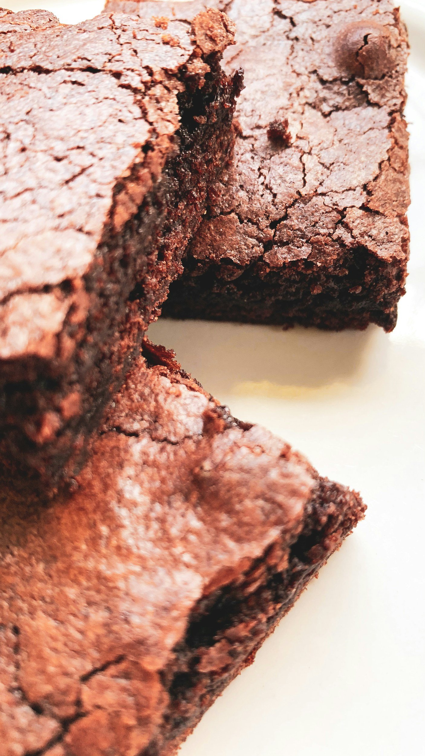 Close-up of a piece of chocolate brownie cake showing its cracked surface and moist interior.