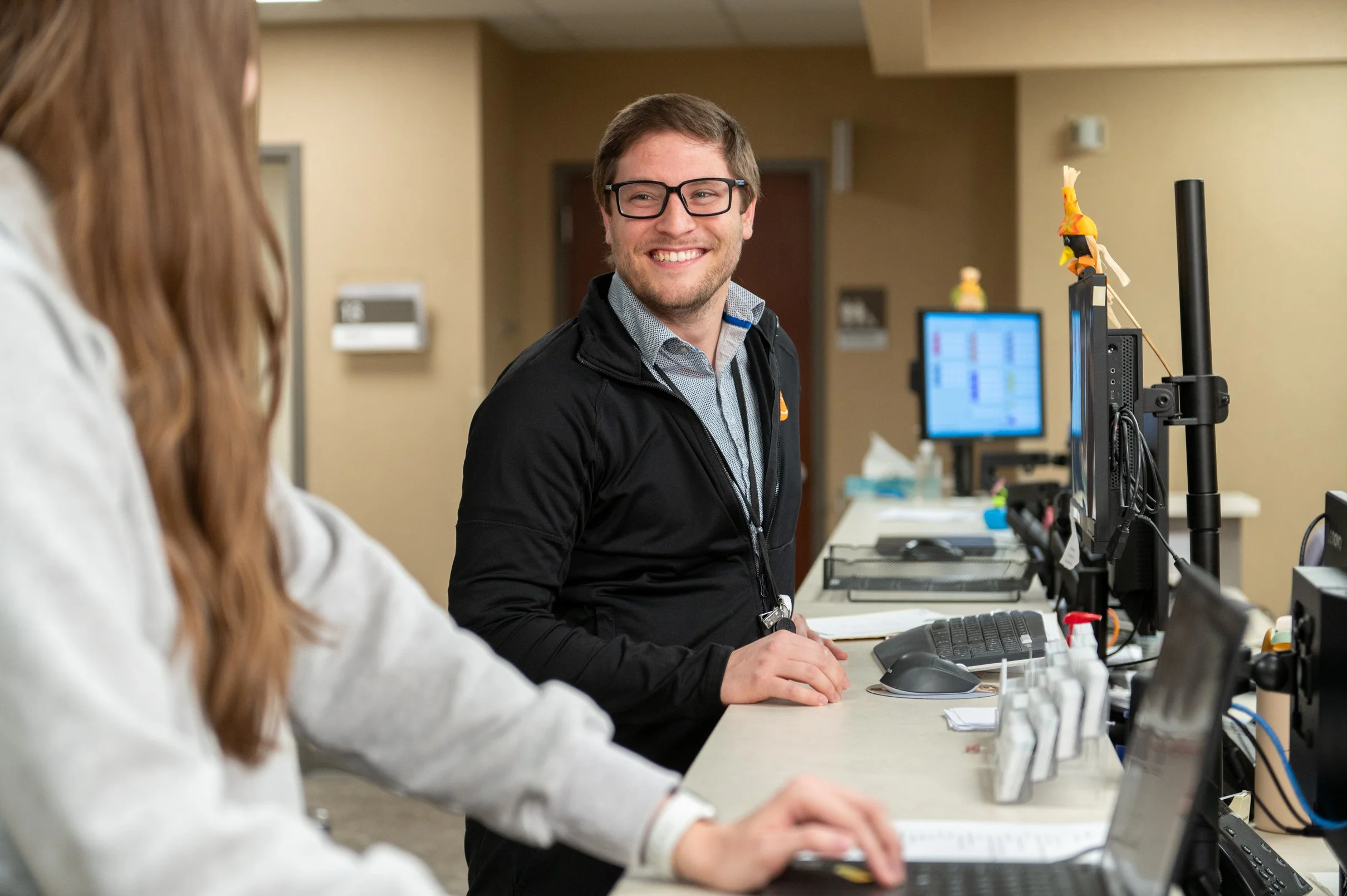 ofc employee smiling at computer