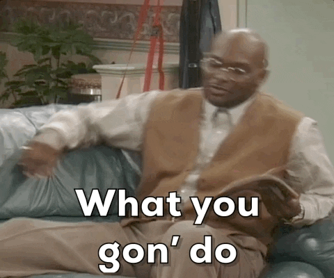 A man sitting on a couch, pointing and speaking with the text "What you gon' do" overlaid.