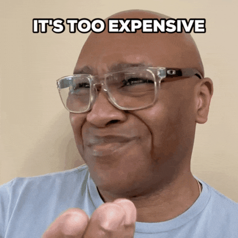 A man with glasses making a funny face, pointing his finger, with the caption 'IT'S TOO EXPENSIVE' at the top.