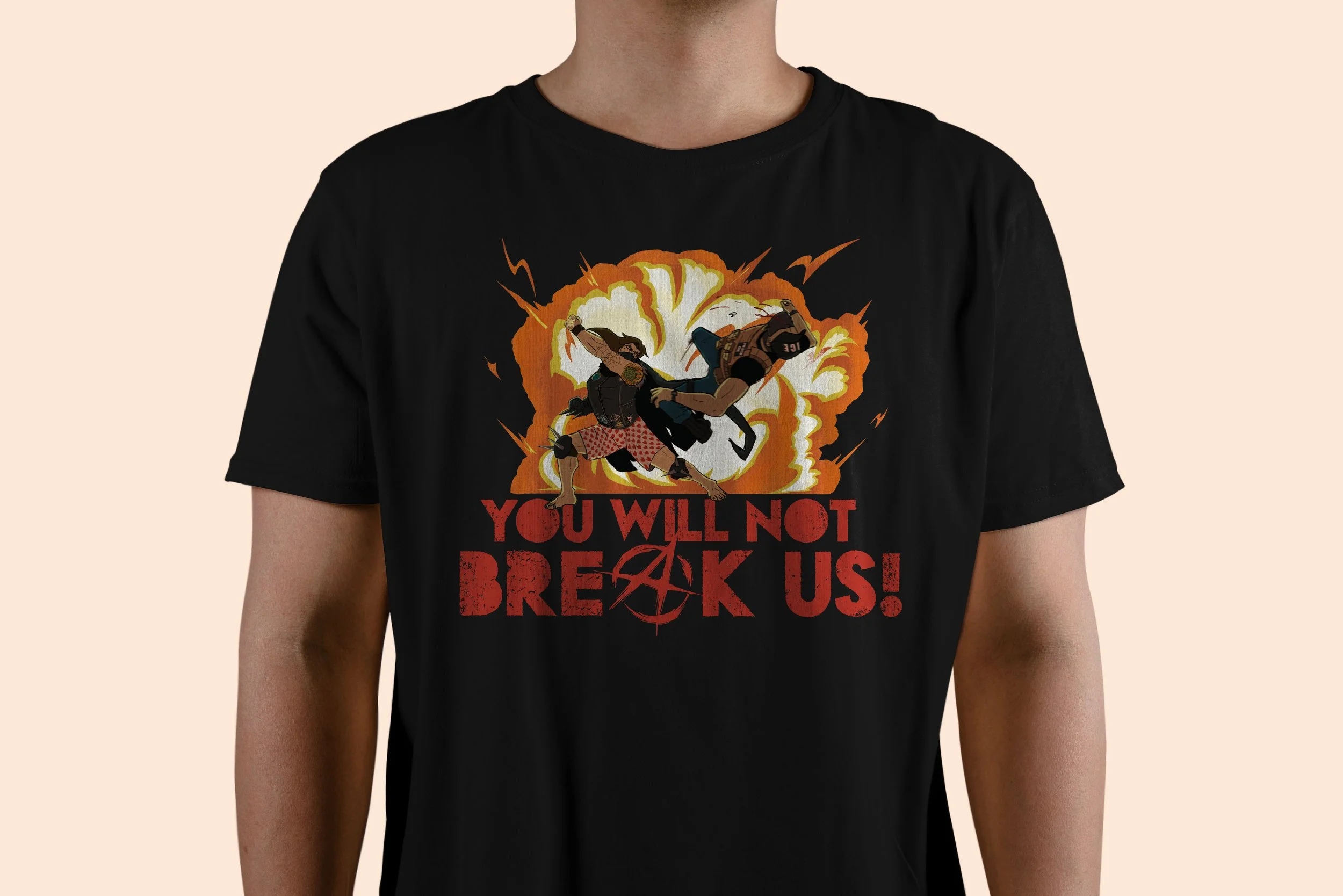 A person wearing a black T-shirt with a graphic of two superheroes fighting each other in front of an explosion. The T-shirt has a caption that says, "You will not break us!"