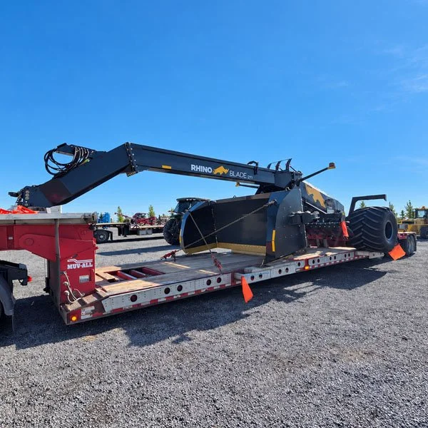 Rhino Blade pull dozer loaded on a red lowboy trailer for transport.