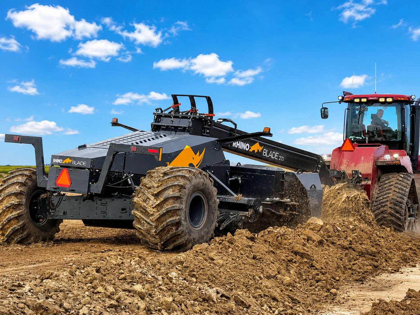 A tractor pulling a black Rhino Blade tiller through a field of dirt, under a blue sky with scattered white clouds.