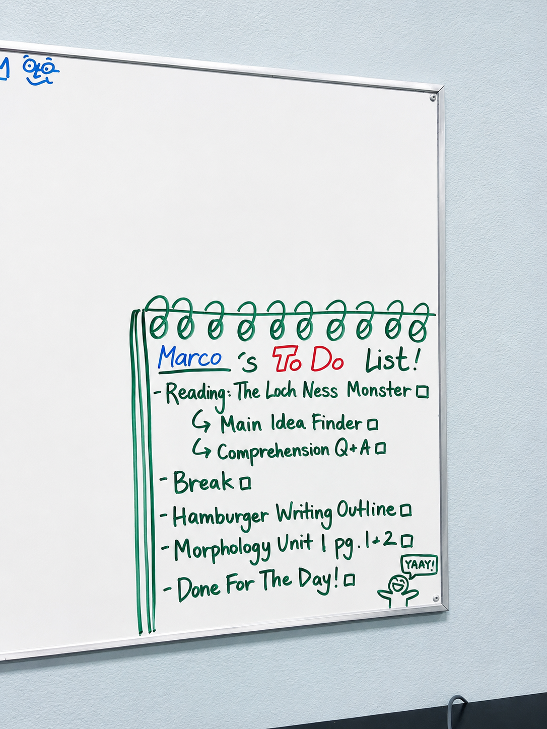 Whiteboard with a green spiral binding, listing a to-do list for Marco including reading, break, writing outline, and morphology units, with a small drawing of a person and the word 'YAY!'