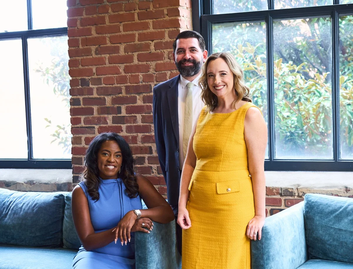 Unified Impact nonprofit consulting firm team working with mission-driven leaders. The three founders pose together smiling warmly.