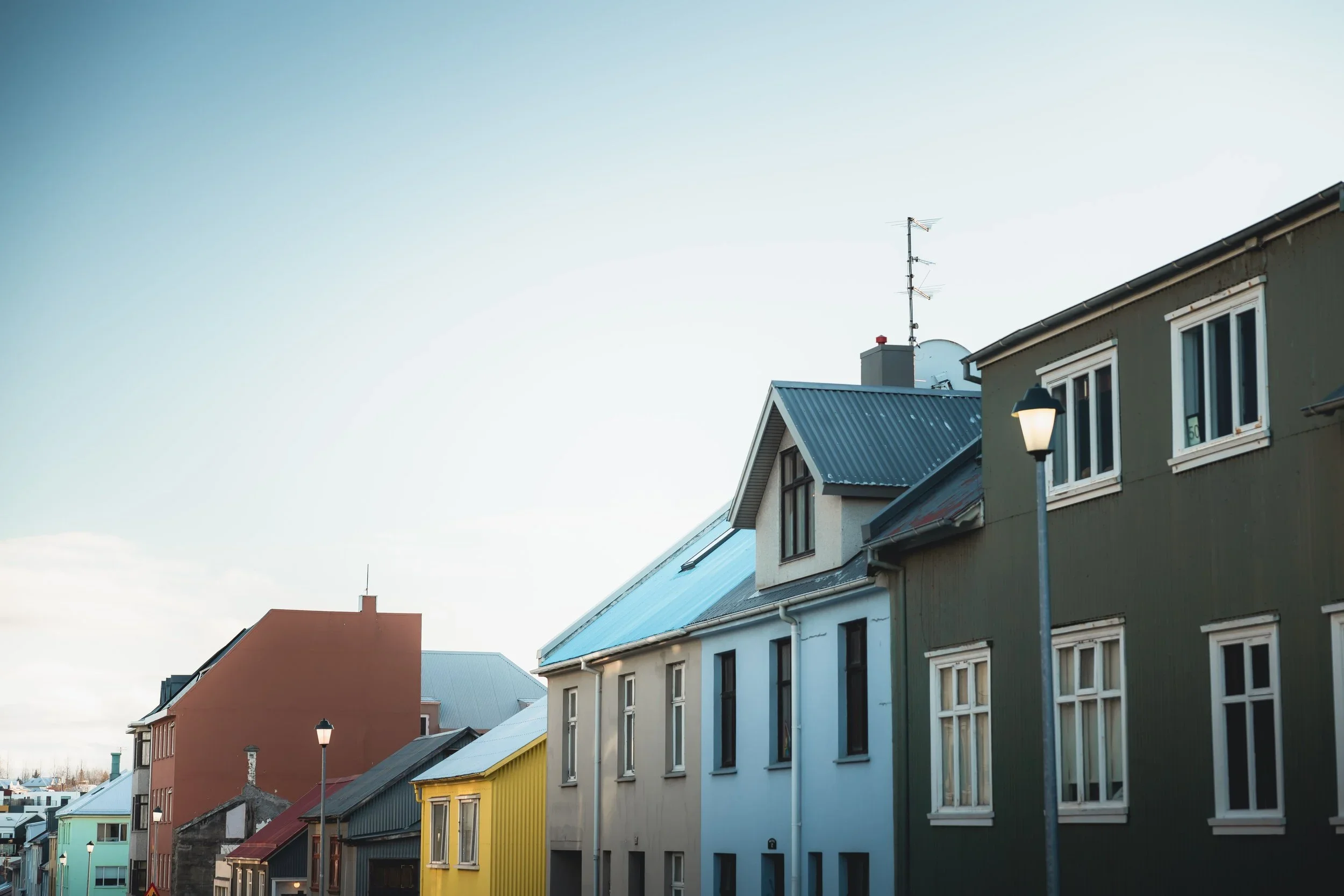 Colorful buildings with various roof styles and a clear sky in the background.