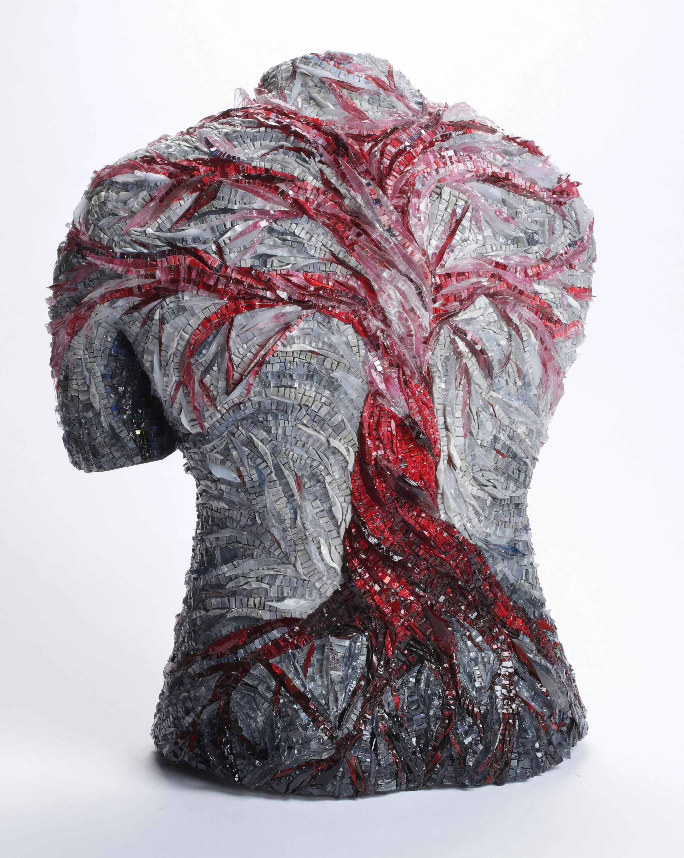 Mosaic sculpture resembling a human head with abstract swirling patterns in red, silver, black, and gray colors.