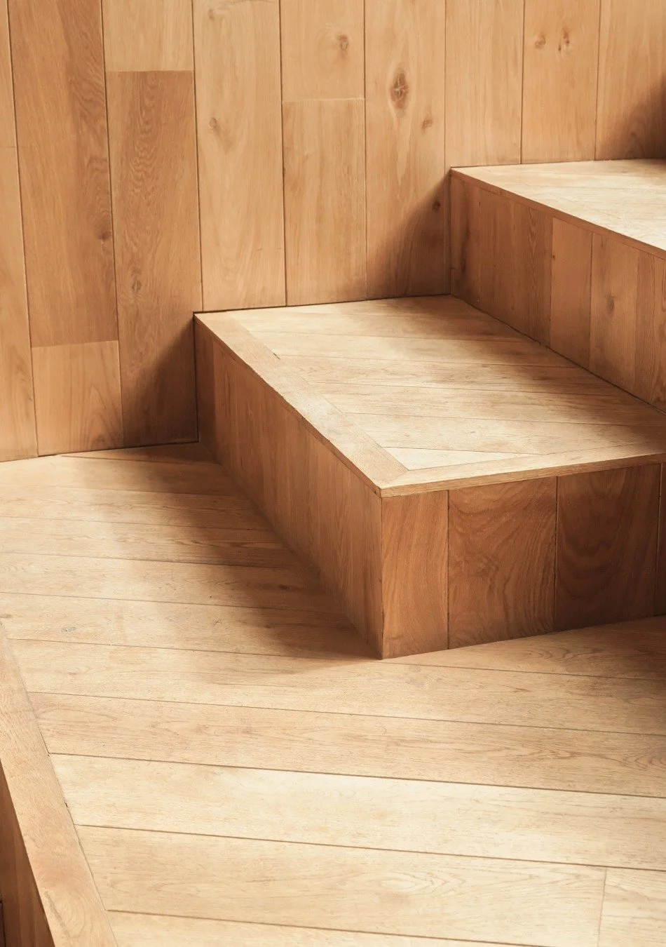 Close-up of wooden stairs and wall with natural wood finish.