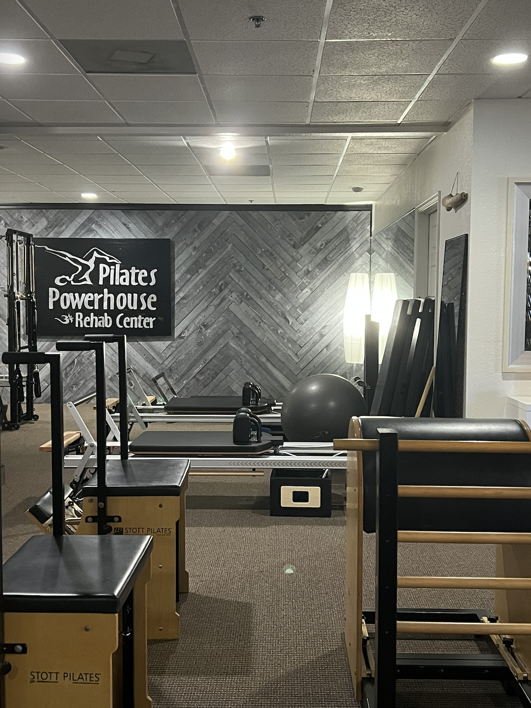 	
Pilates Powerhouse And Rehab Center Studio In St Petersburg, Florida - Interior of Pilates Powerhouse Rehab Center with Pilates equipment, exercise balls, and a wooden wall accent.
