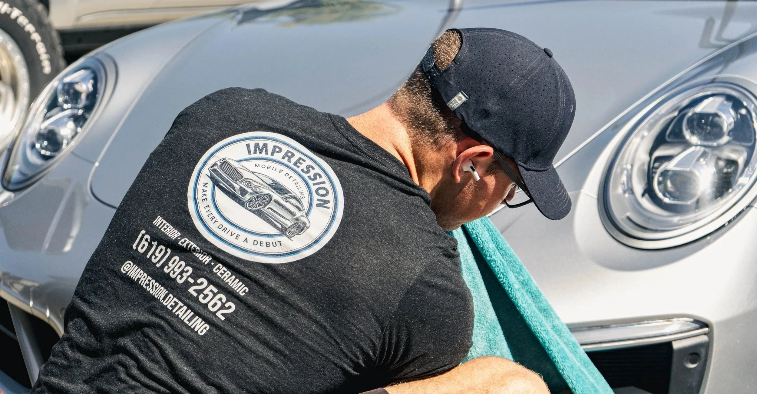 Impression Detailing owner hand-detailing a silver Porsche in San Marcos, CA