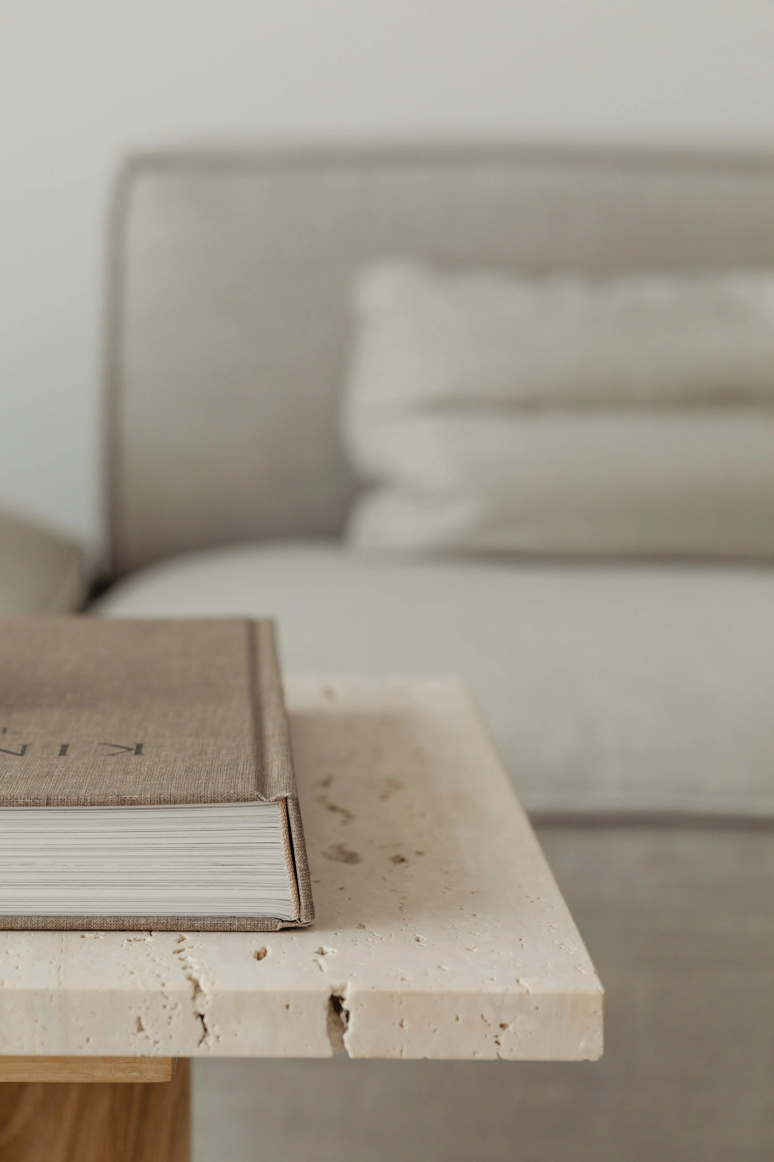Close-up of a stack of books on a white marble or stone surface, with a blurred background.