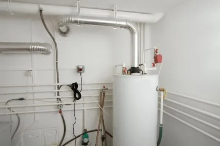 A utility room with a water heater, pipes, and a fire extinguisher on the wall.